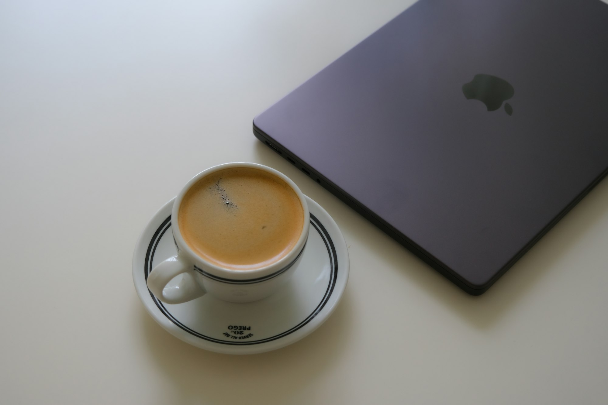 A laptop and an espresso cup on a table