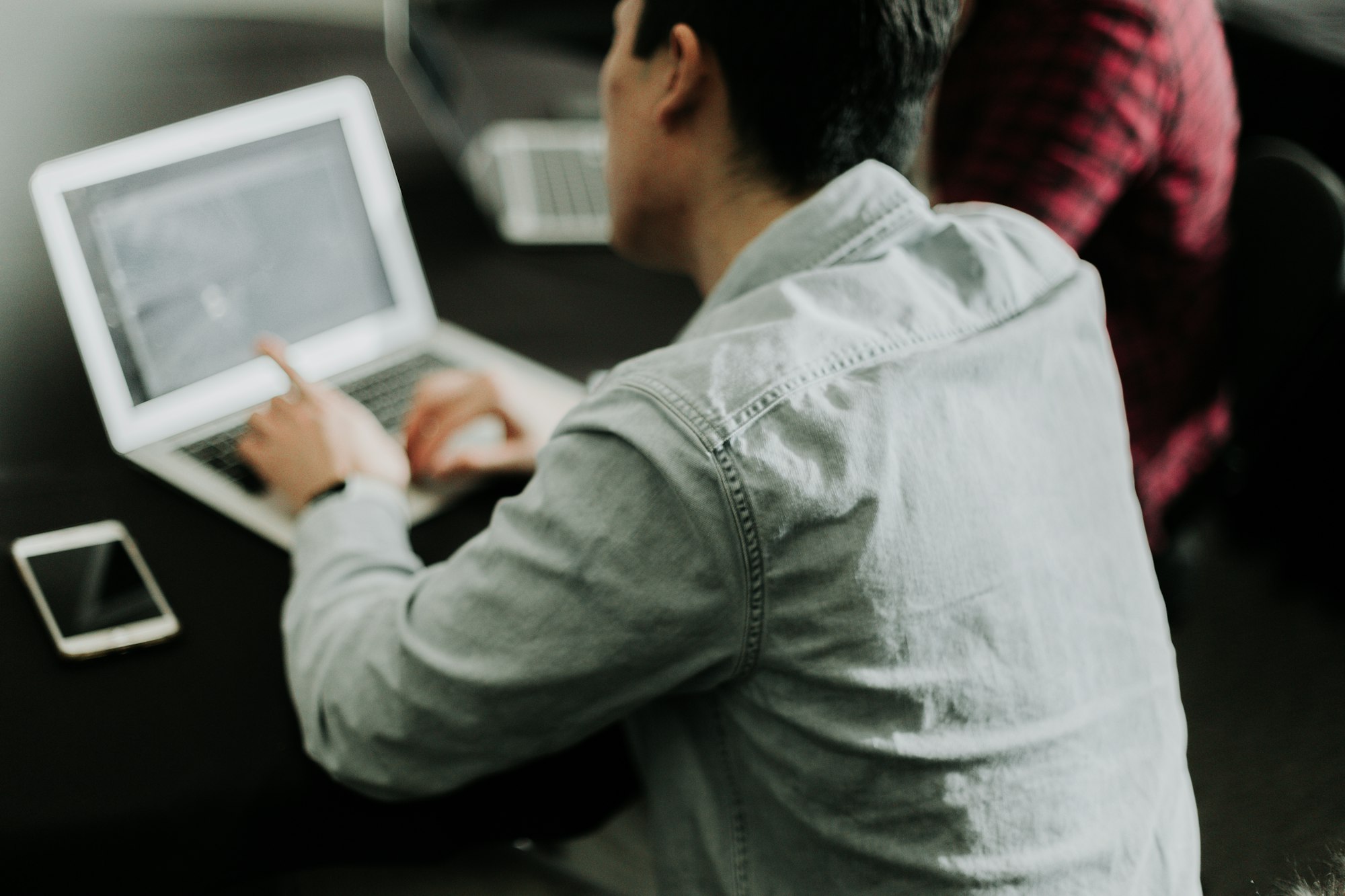 A person typing on a laptop at a table