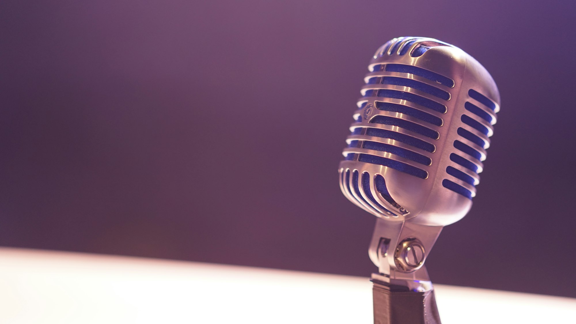 A condenser microphone against a black background