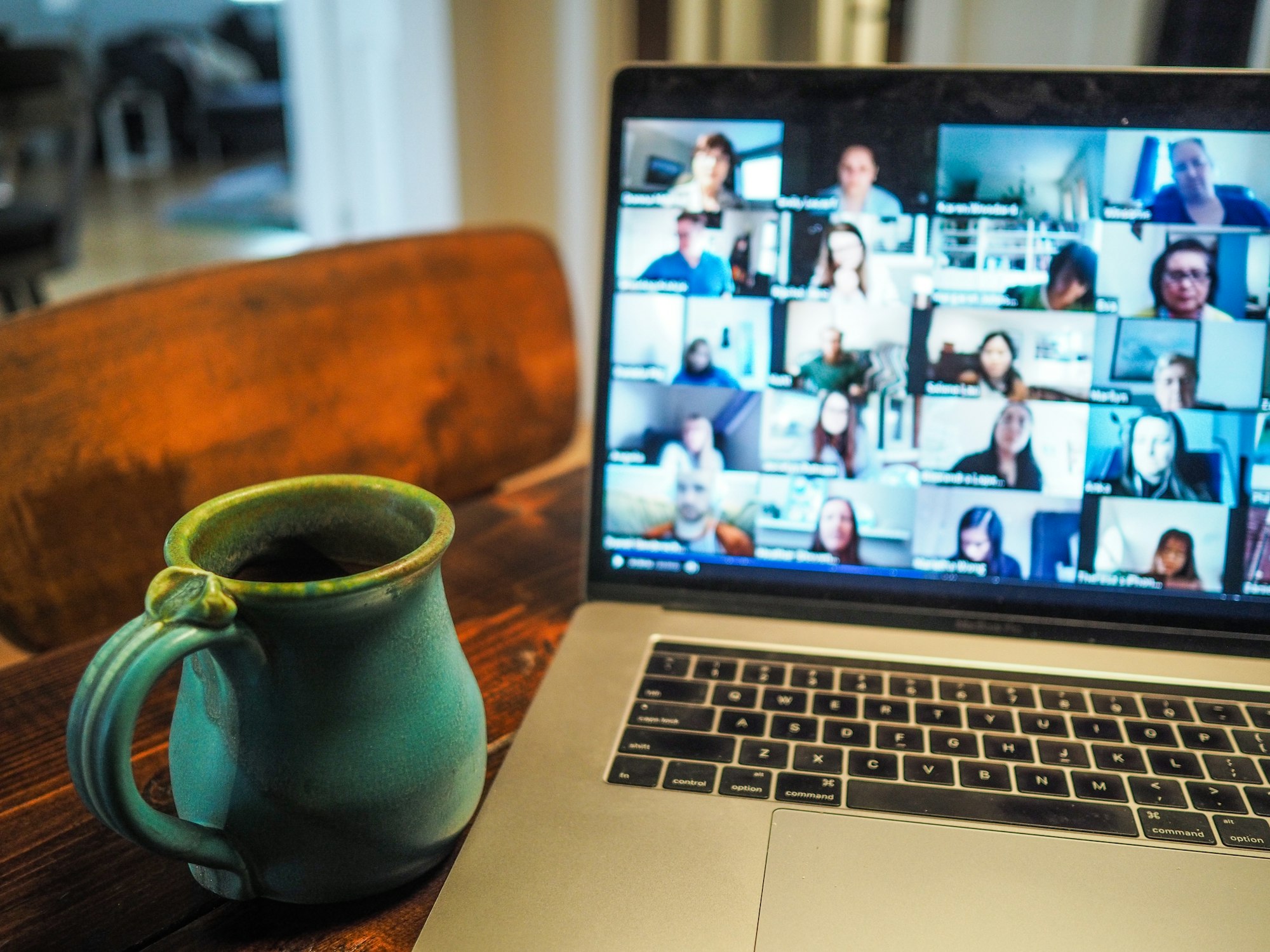 A laptop screen showing a video call with several people