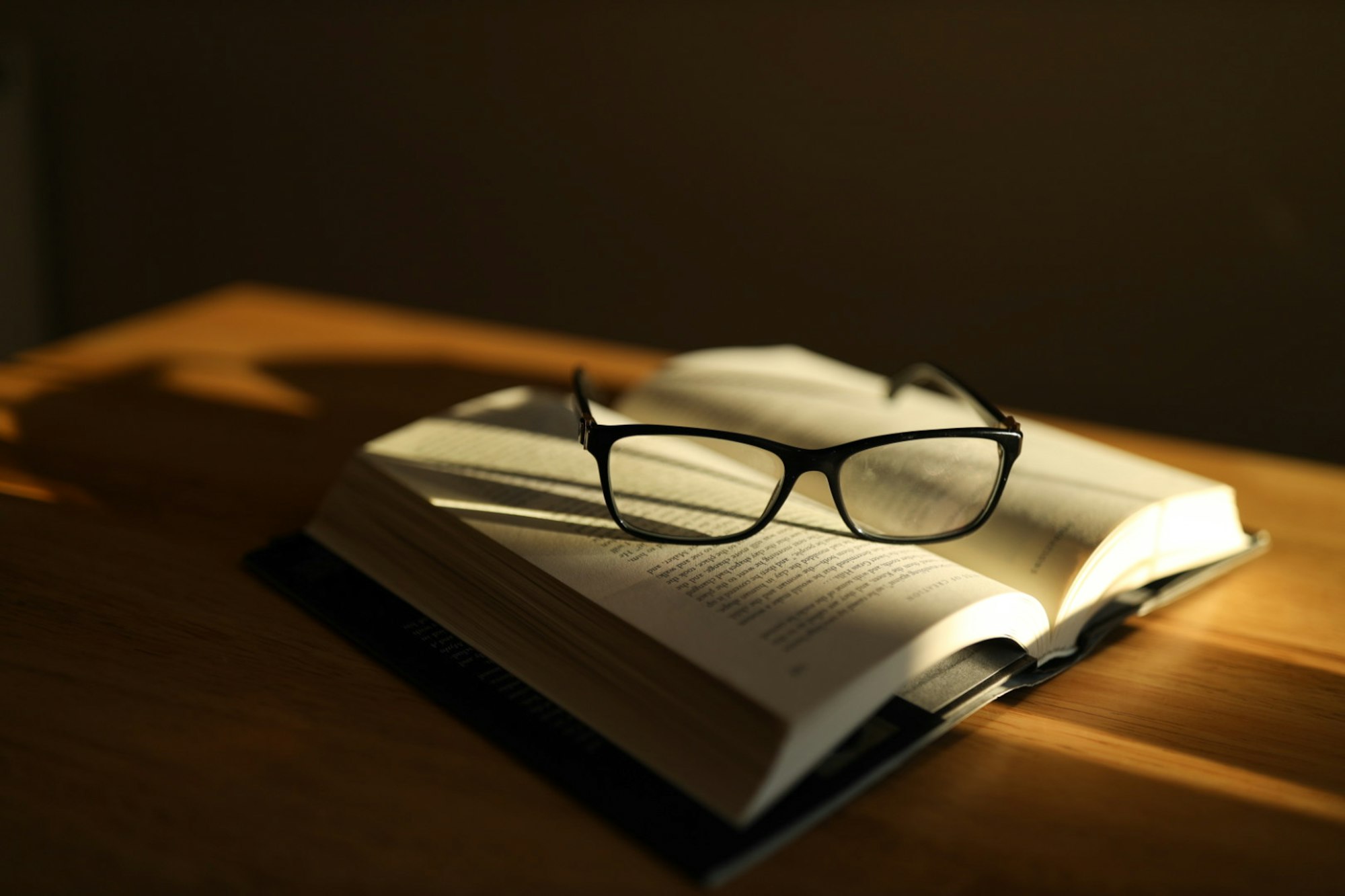 Black framed eyeglasses resting on an open book page