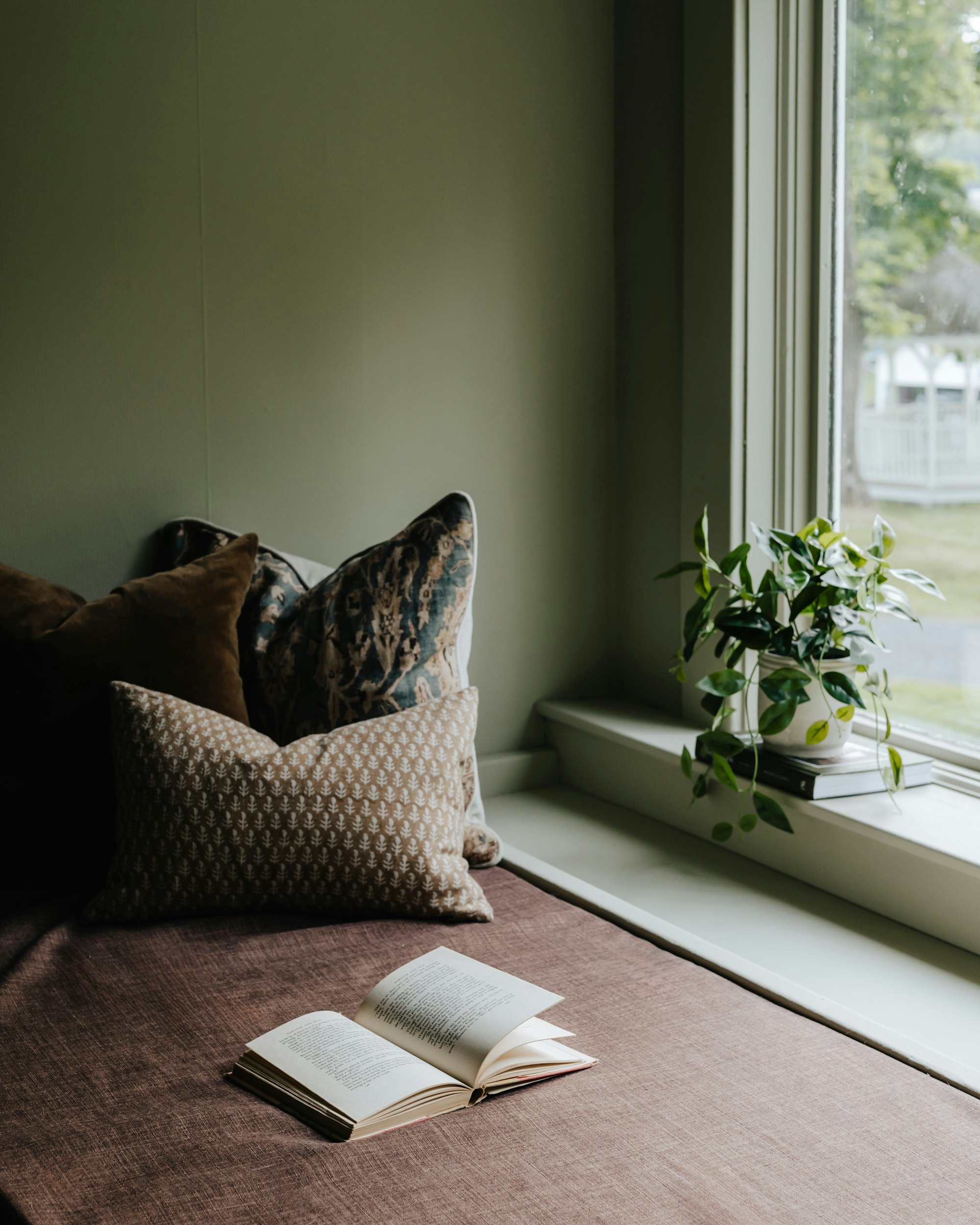 Open book on a cozy reading nook by a window