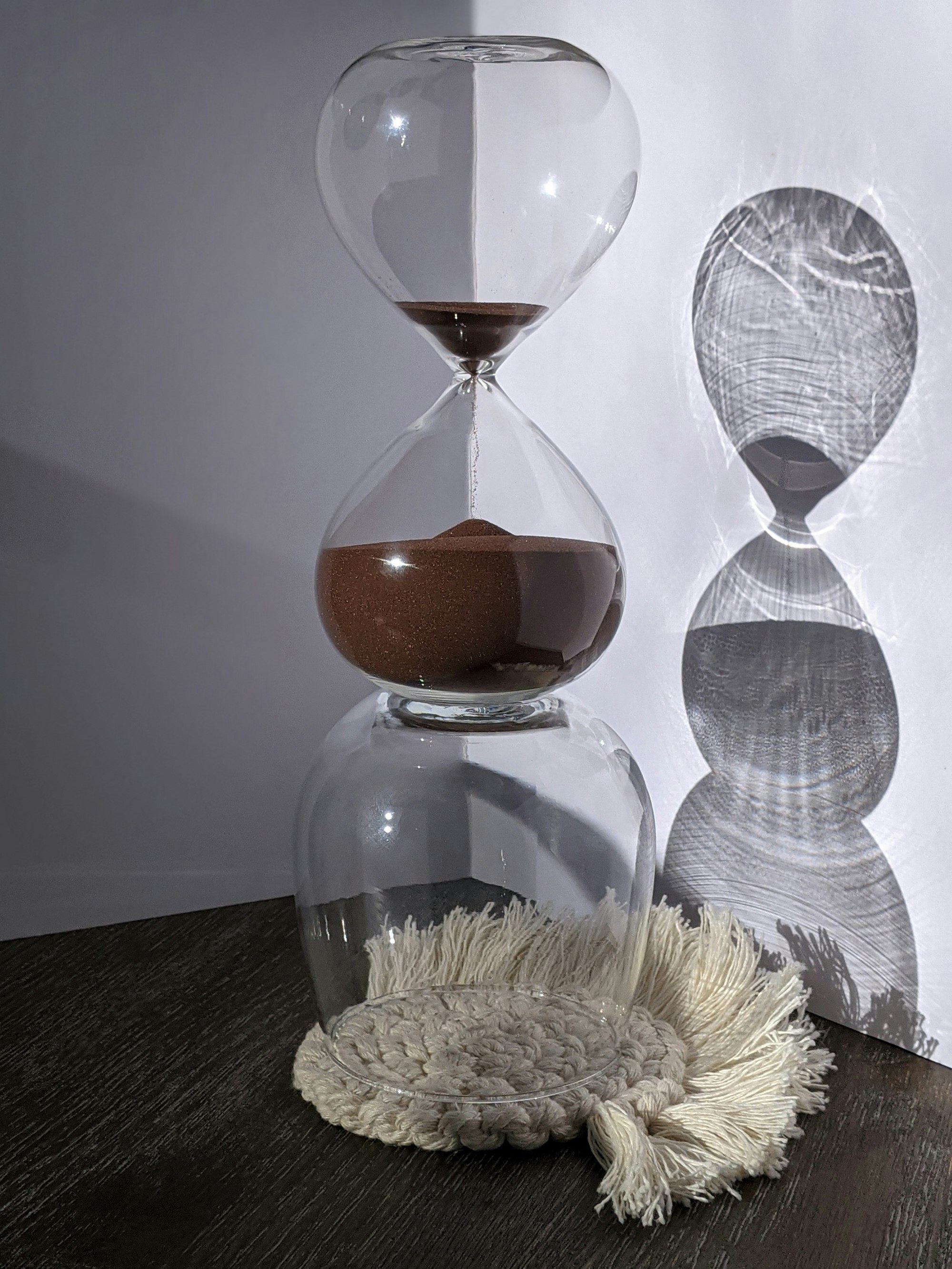 Clear glass hourglass on a black table