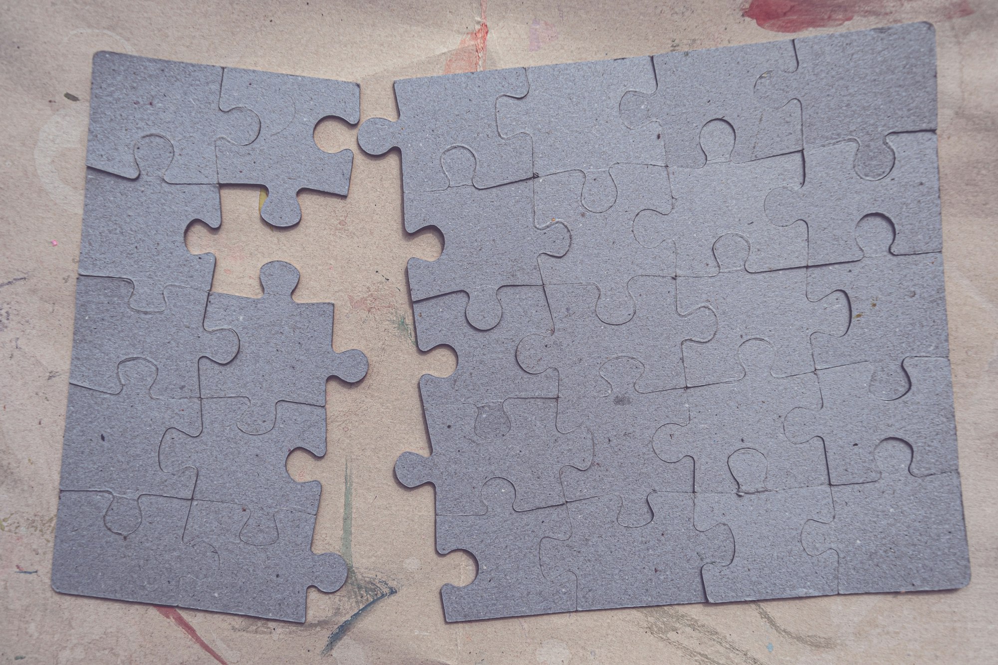 Two pieces of a puzzle laying on top of each other