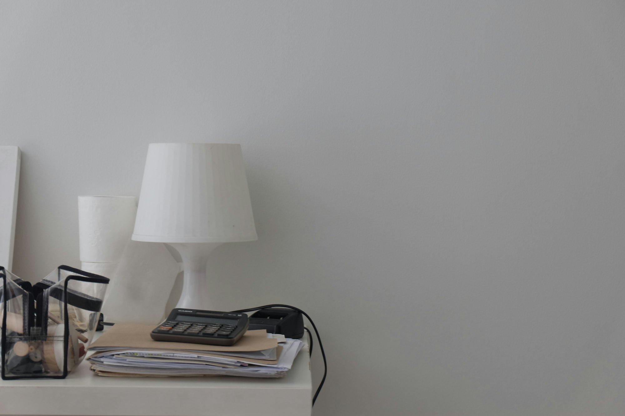 A white table topped with a lamp and a phone