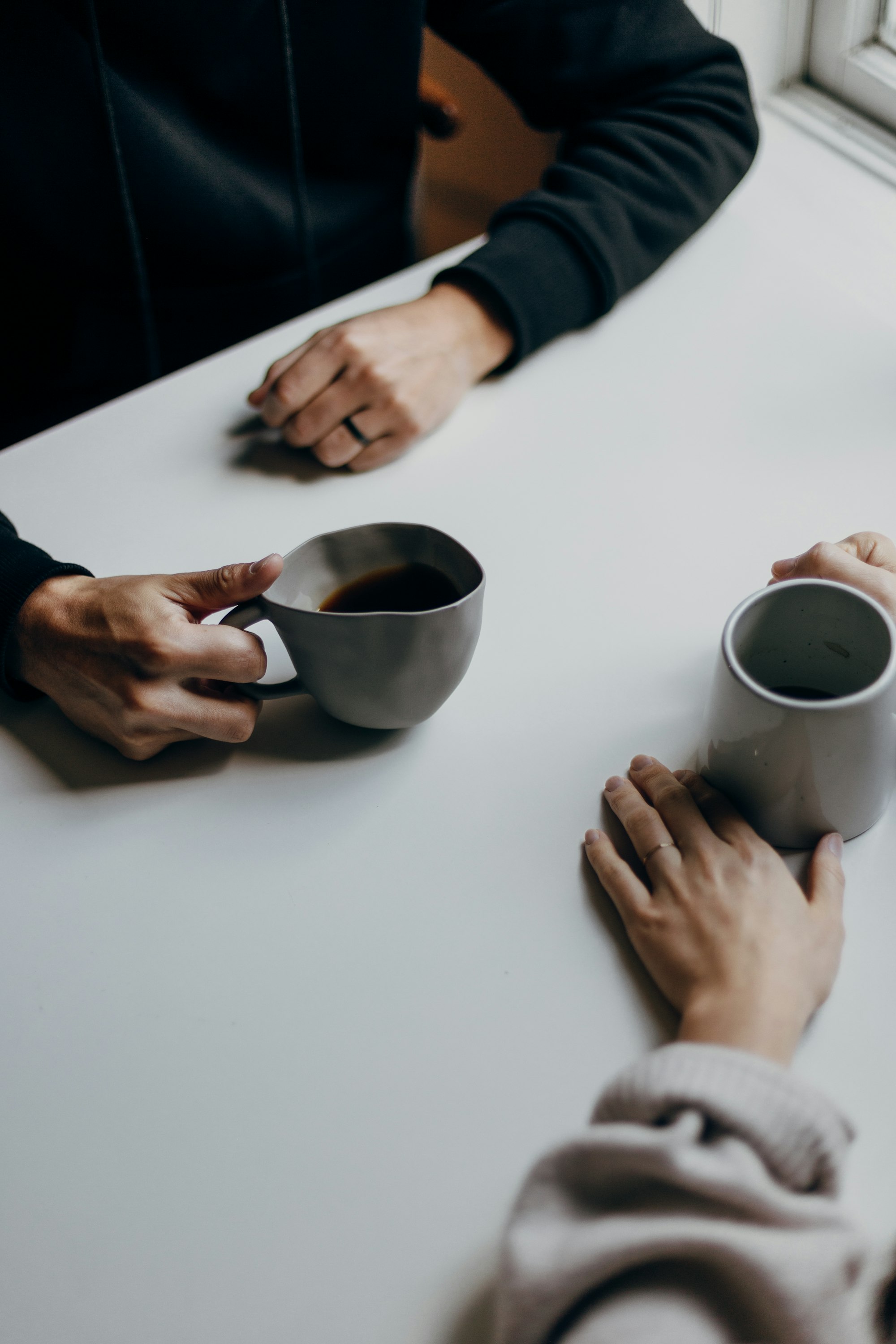 Two people in conversation over coffee at a table