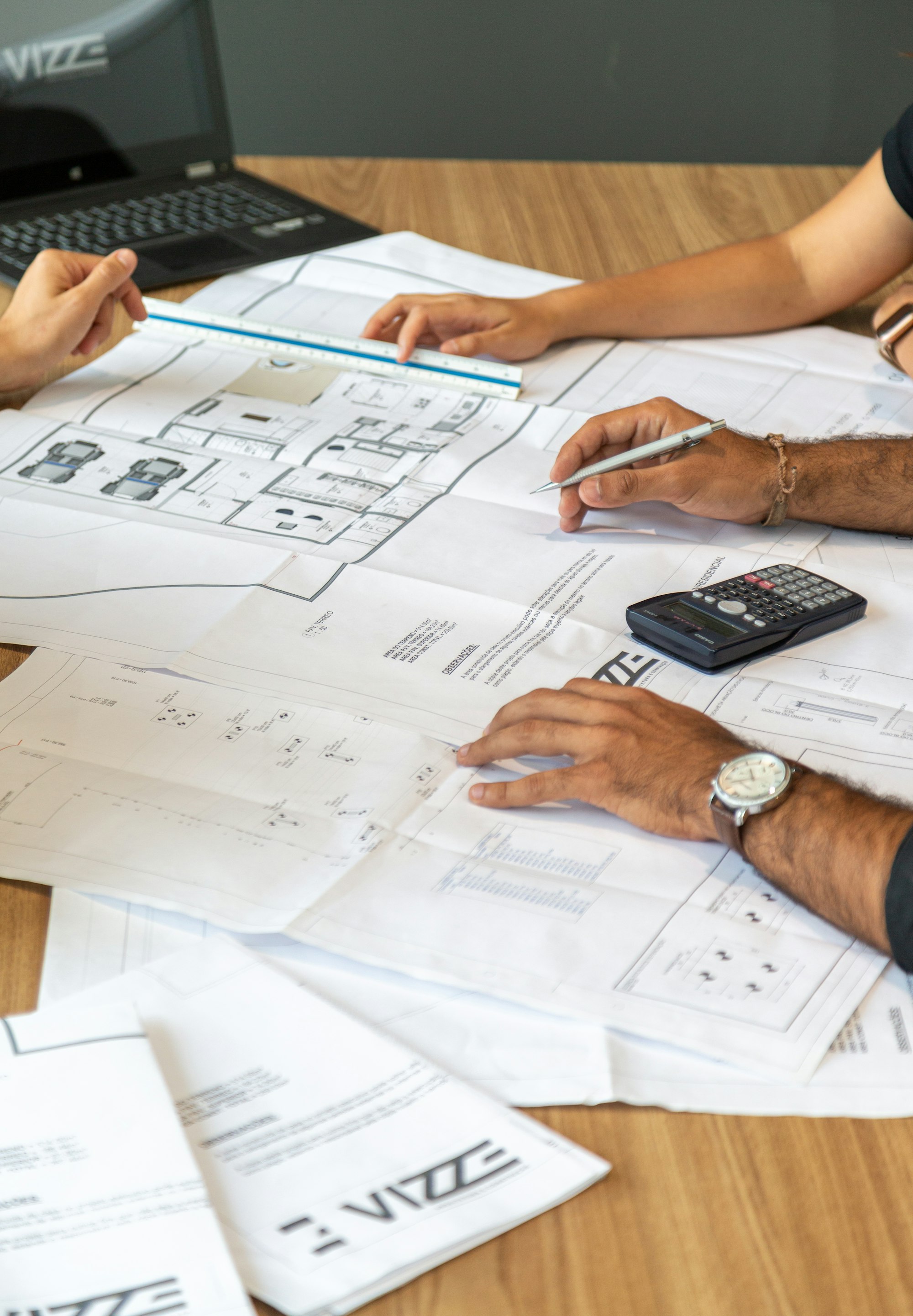People reviewing architectural blueprints on a desk