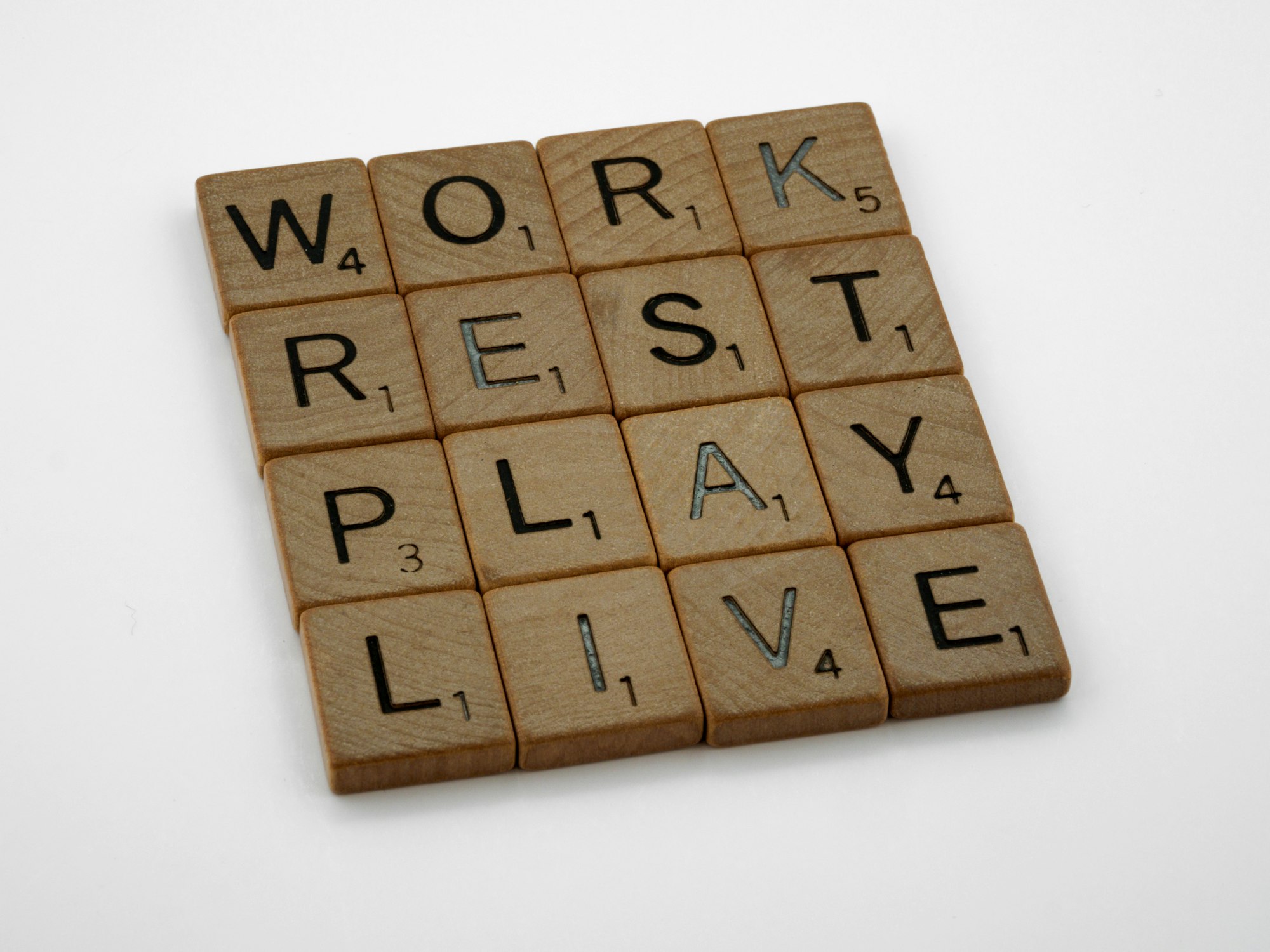 Scrabble tiles spelling out work rest play live