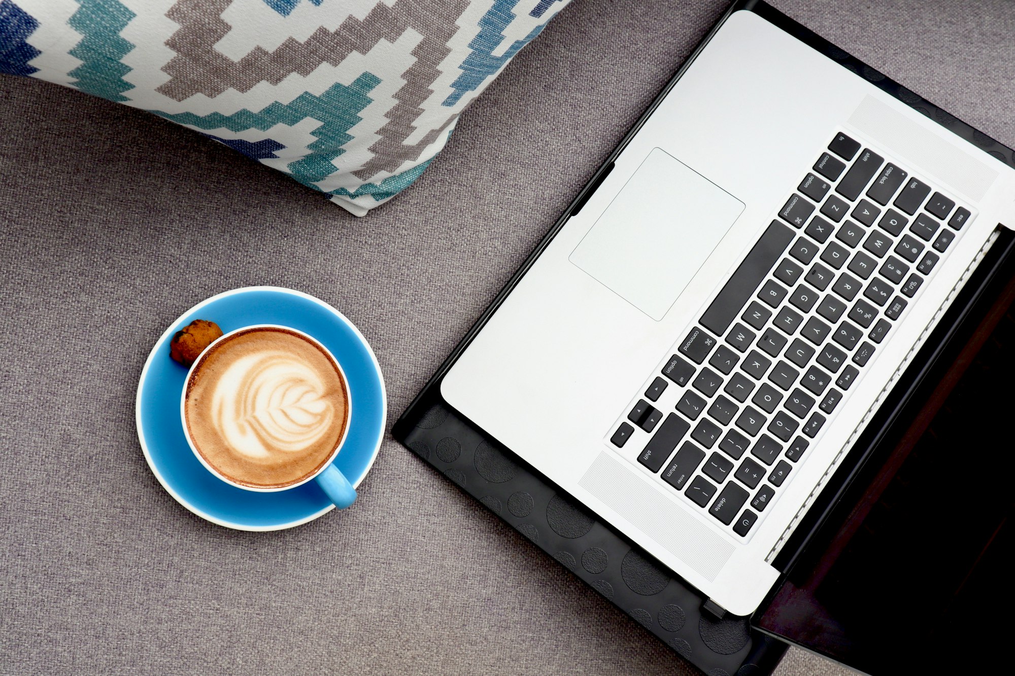White ceramic mug with coffee beside MacBook Pro