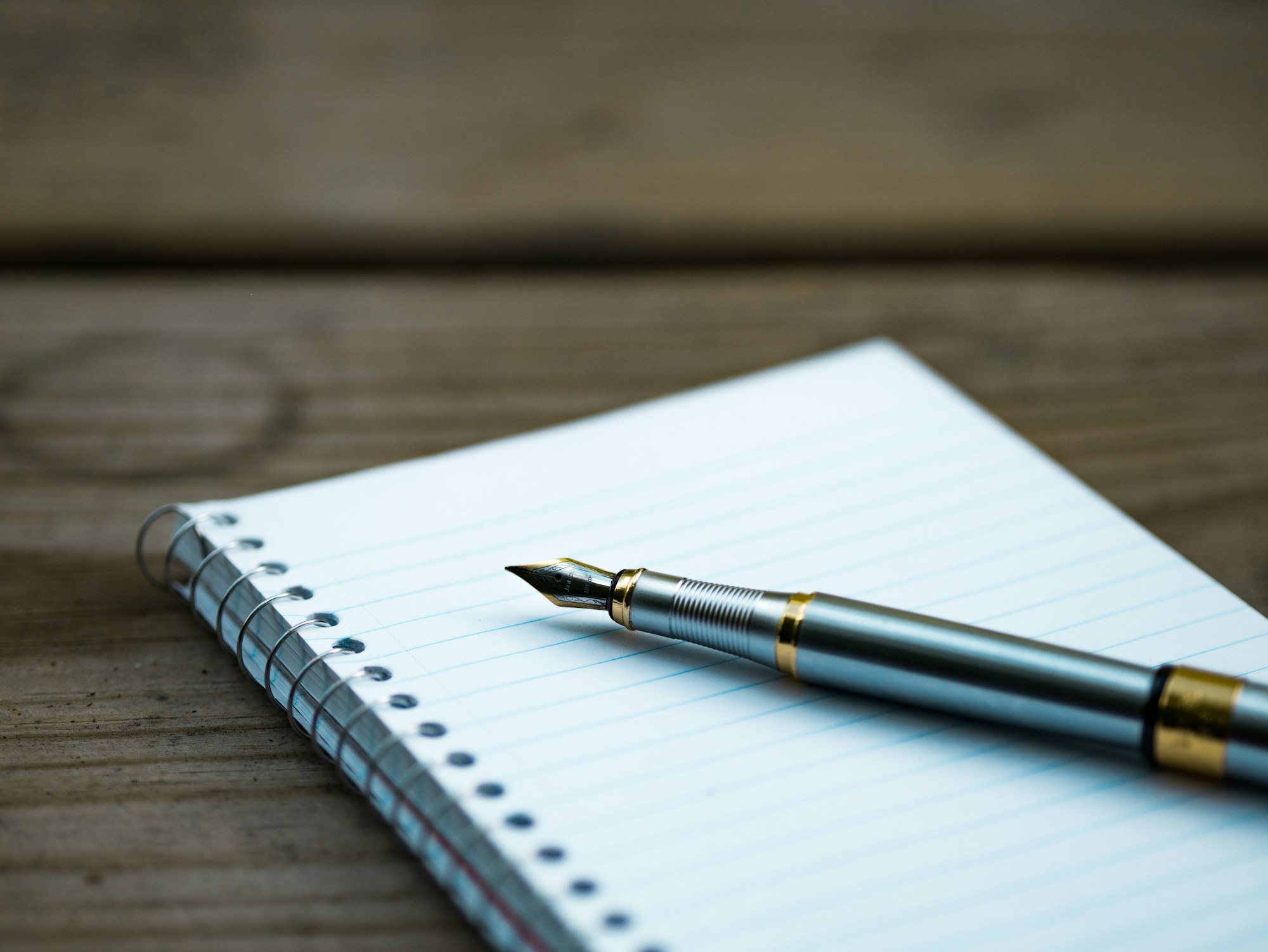 A fountain pen resting on an open notebook