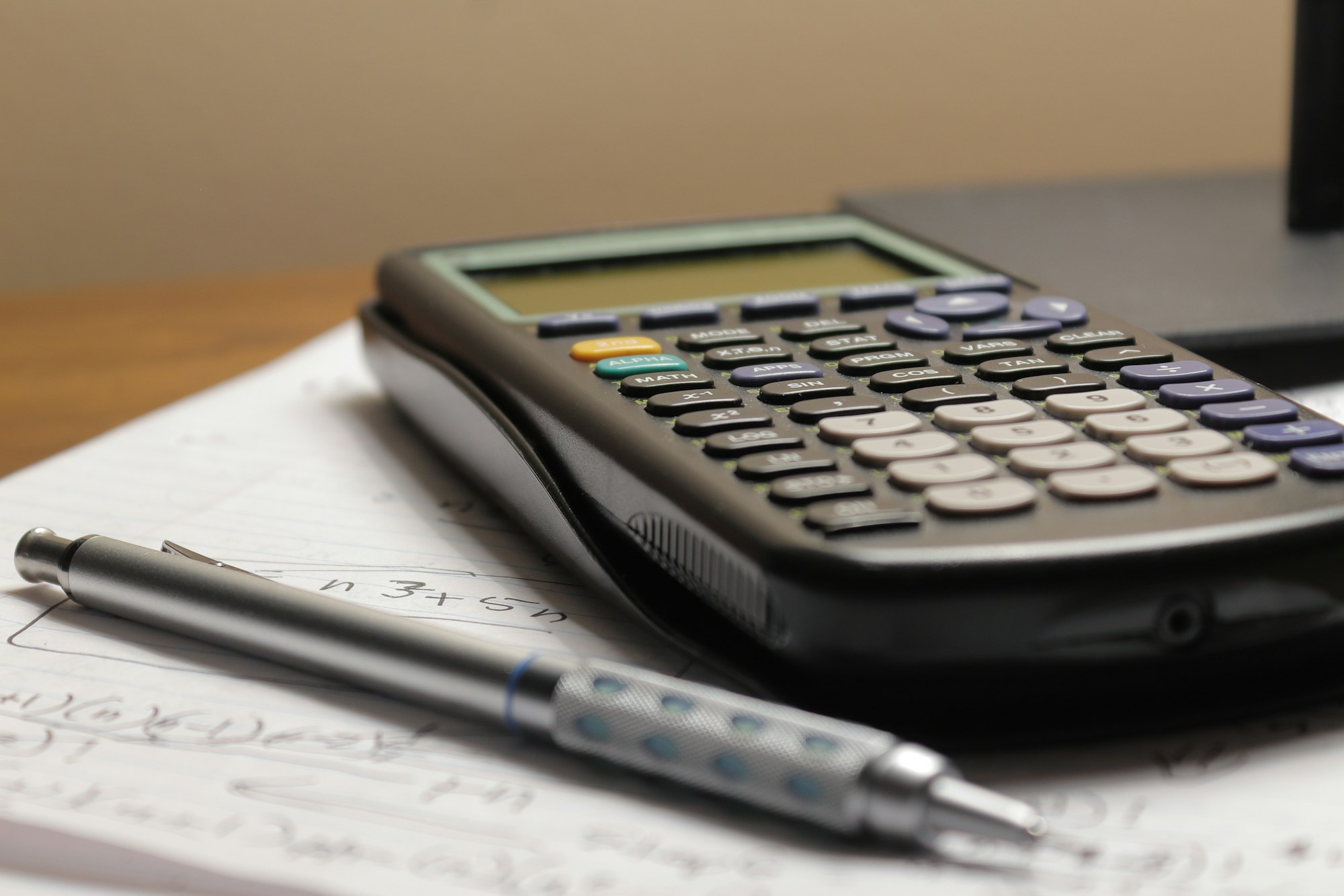 A calculator and pen resting on paperwork