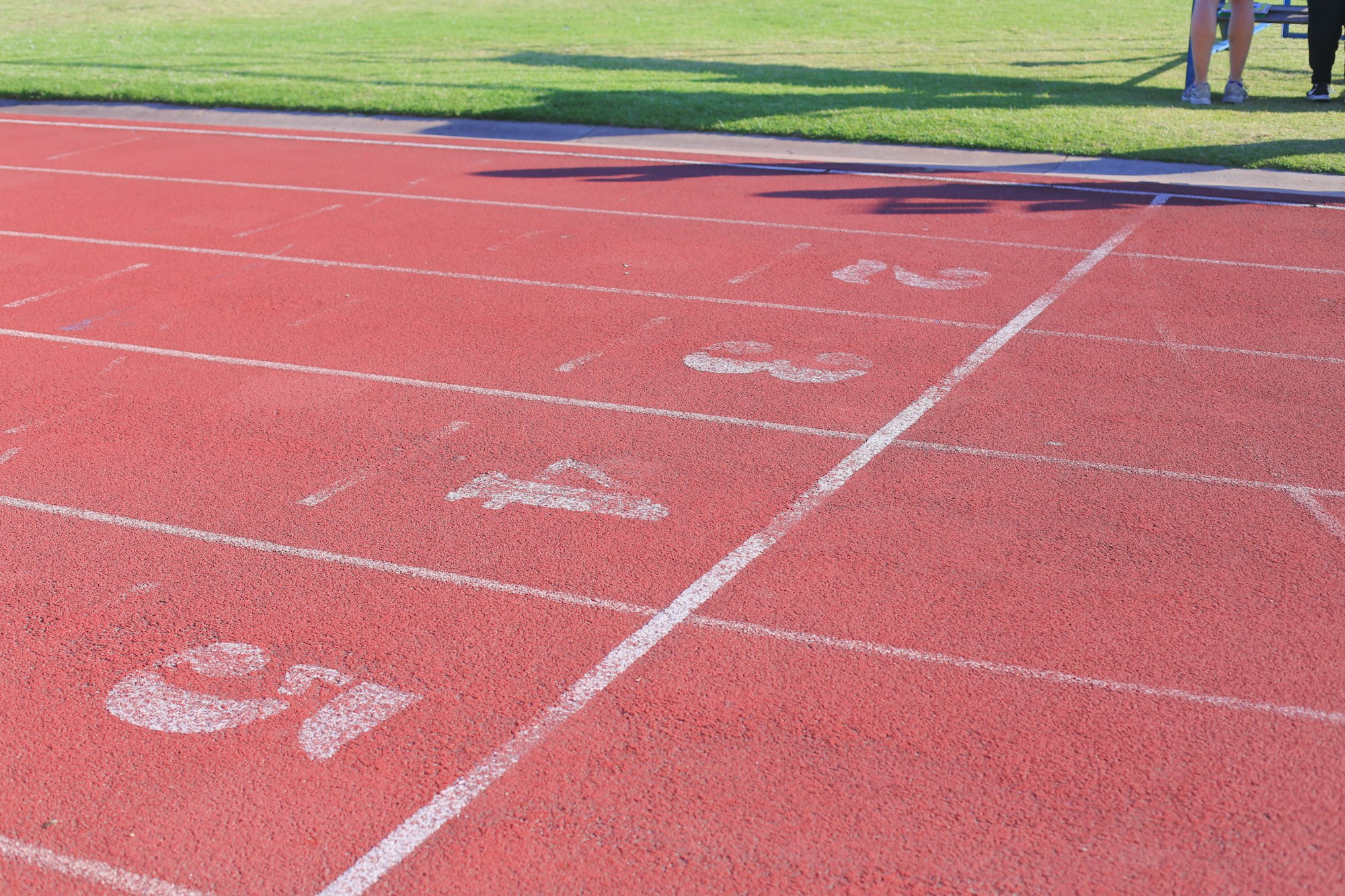 Red running track with numbered lanes at the starting line