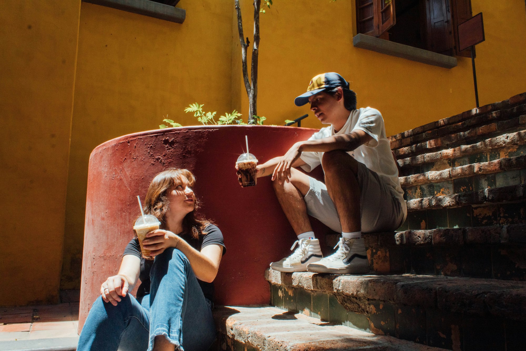 A man and a woman sitting on the steps of a building talking