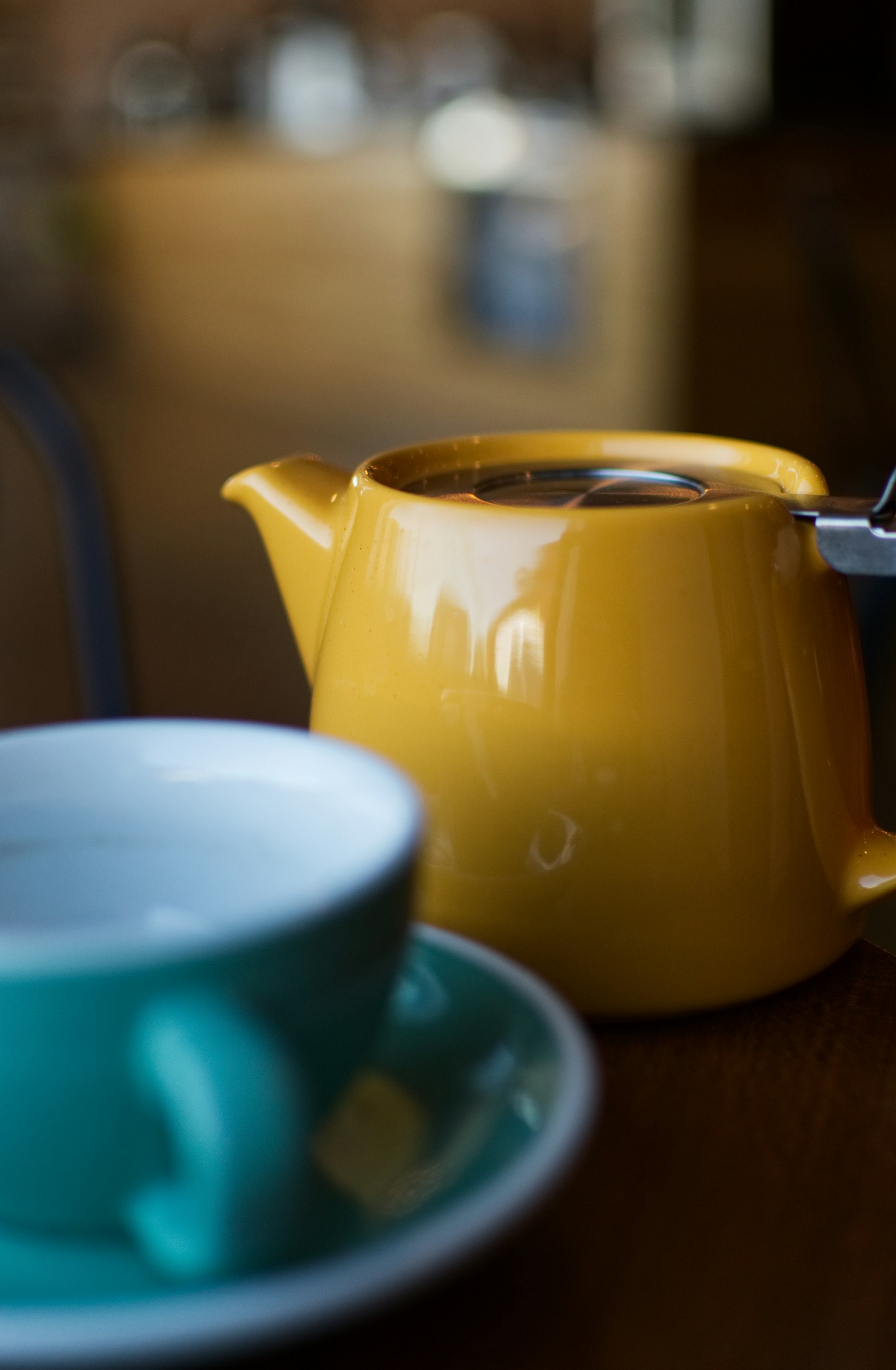 Shallow focus photography of a yellow ceramic teapot