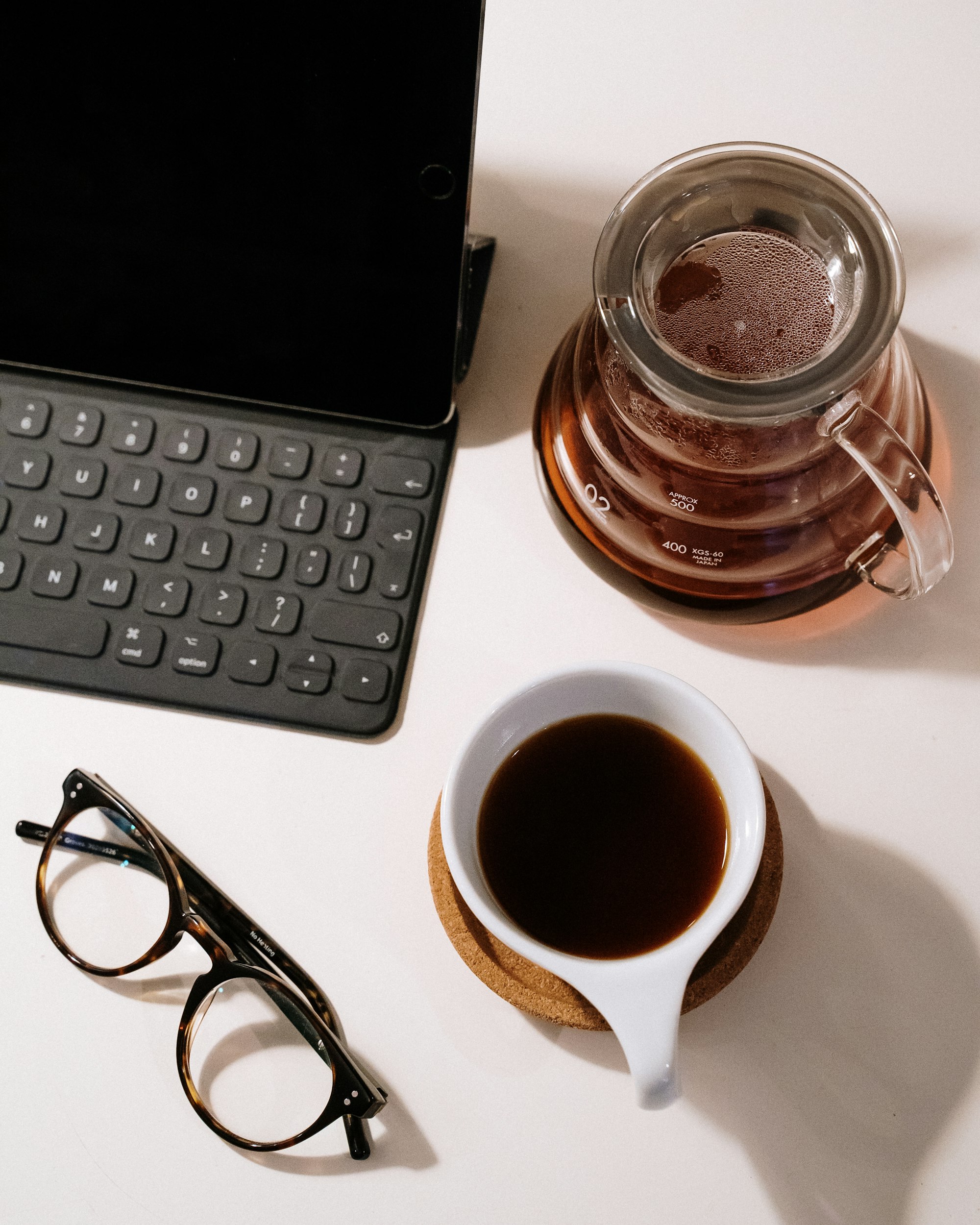 Black framed eyeglasses beside black laptop computer