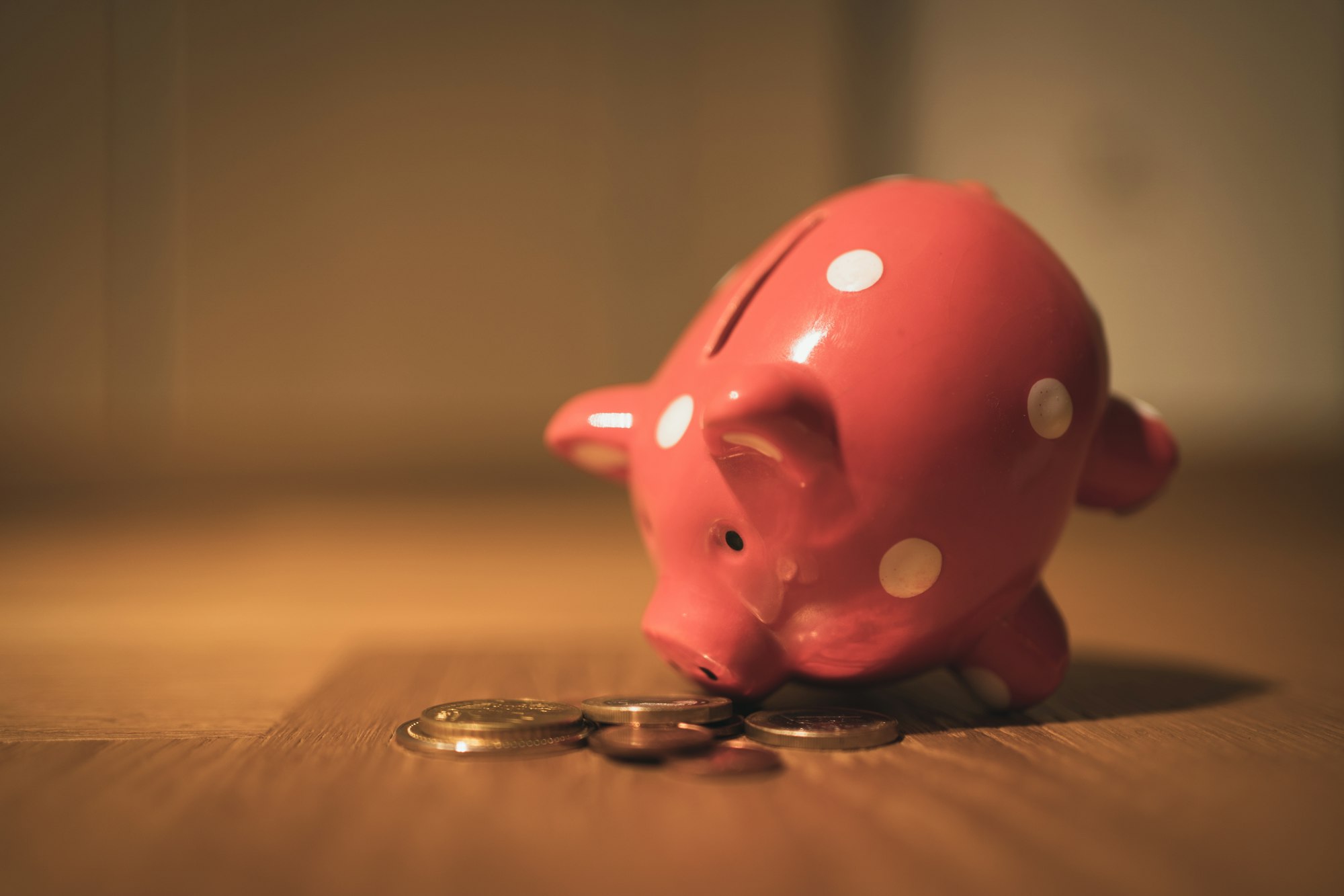 A pink piggy bank on a wooden table