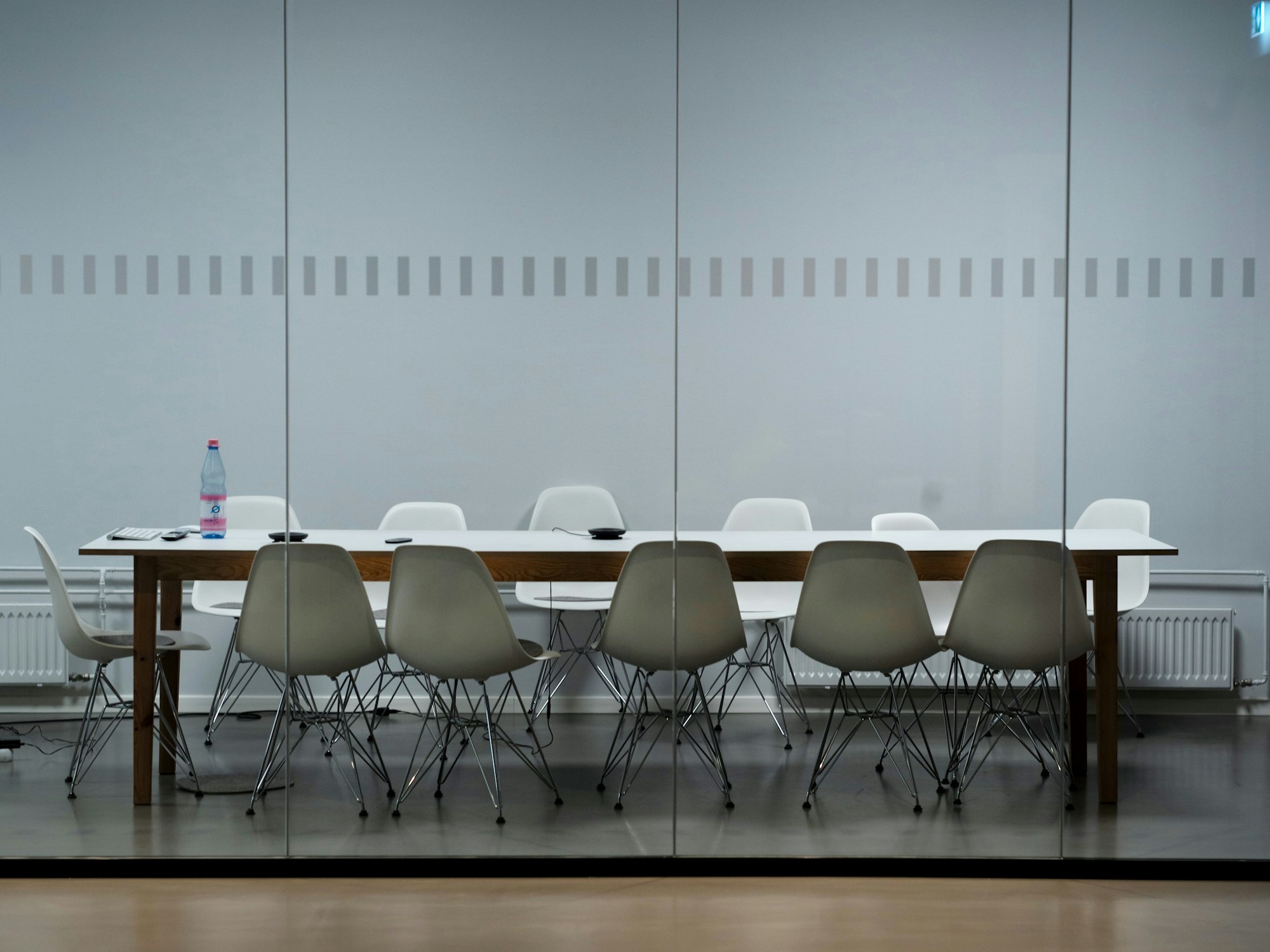 An empty meeting room with a long table and chairs