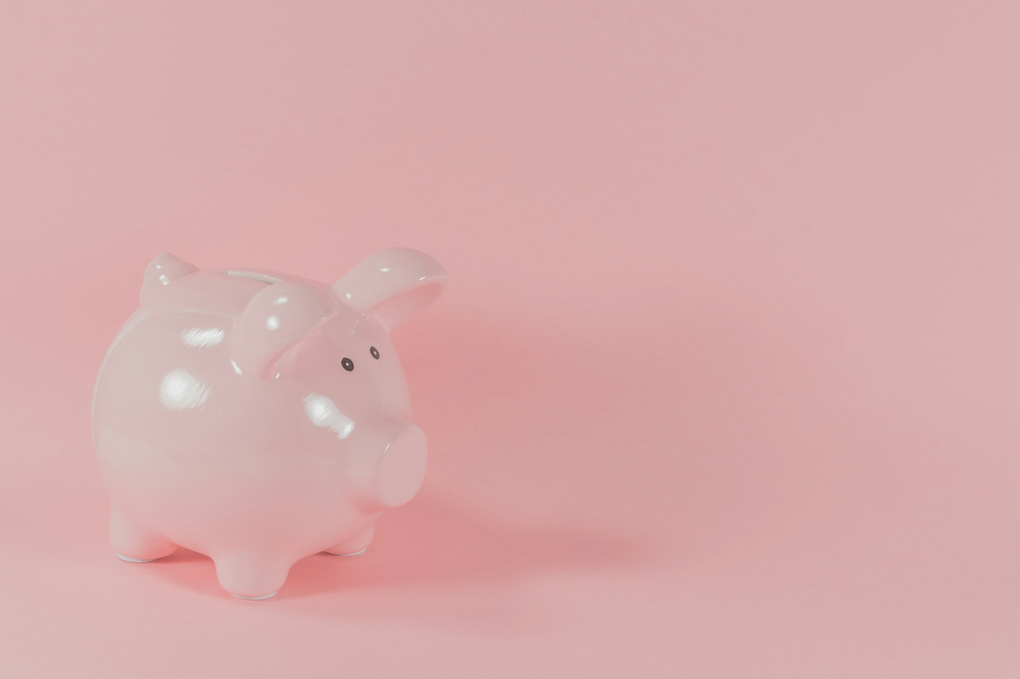 Pink ceramic piggy bank representing savings and financial independence