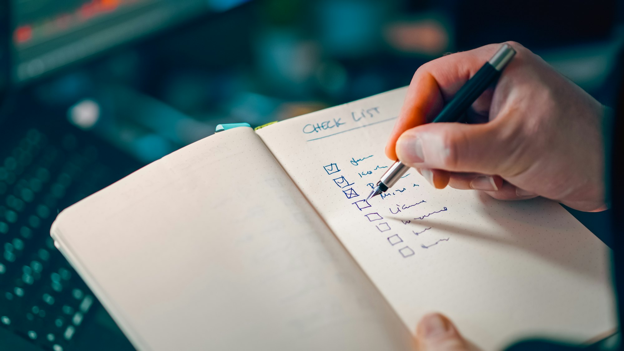 Hand writing a checklist in a notebook