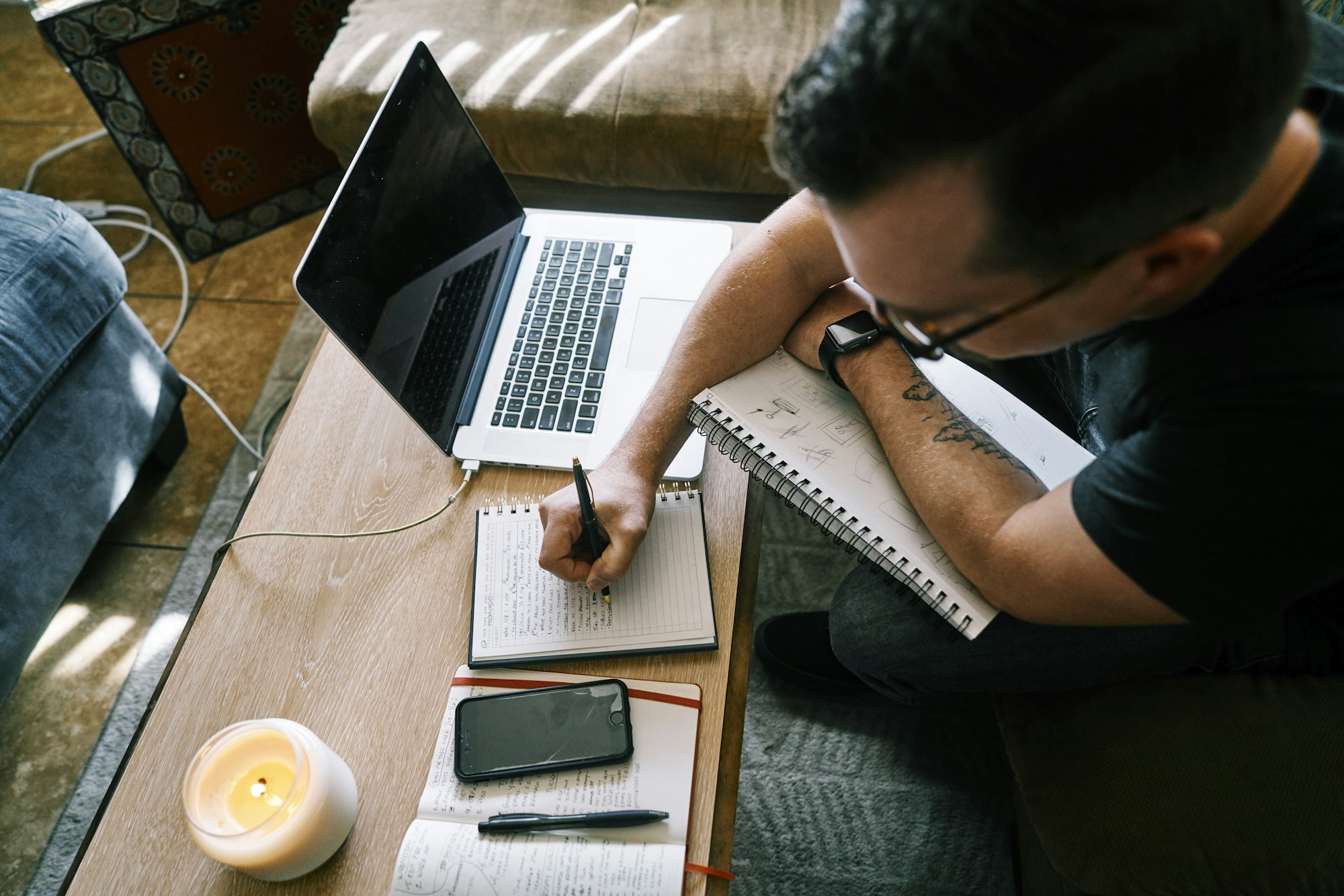 Man in black t-shirt writing on white paper