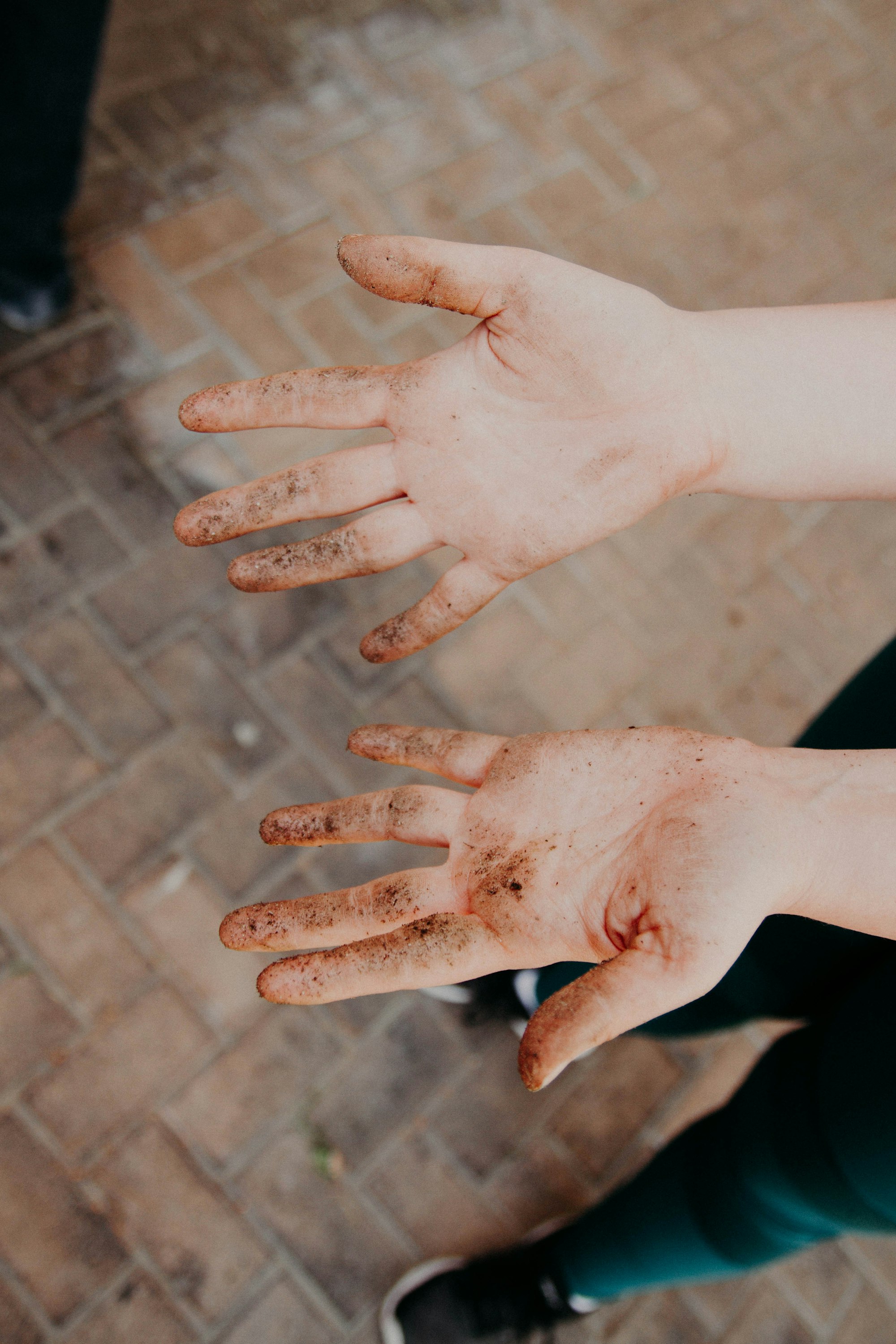 Weathered hands working with clay on a pottery wheel