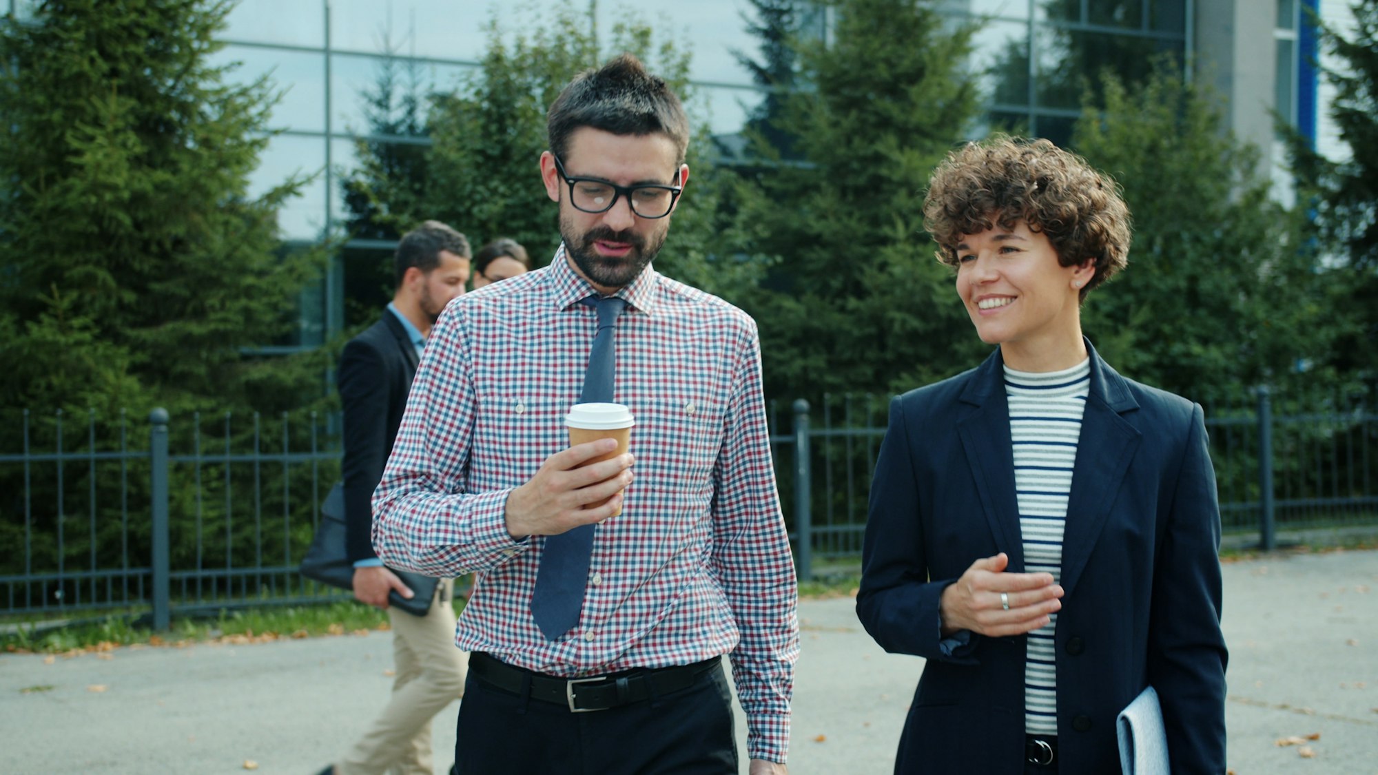 Two colleagues walking and talking outside an office building