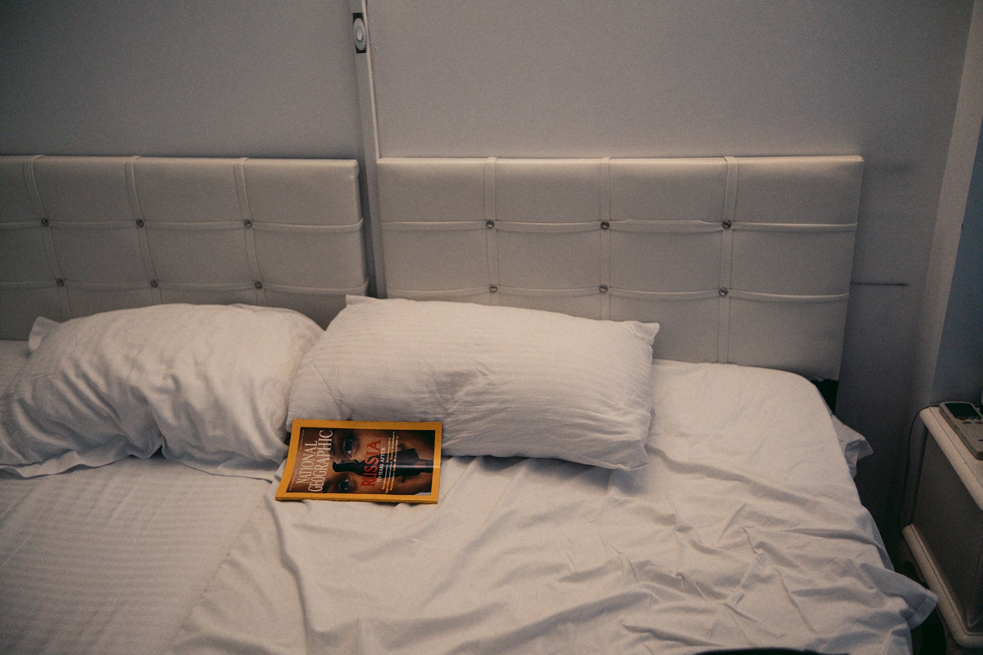 A bed made with white pillows and sheets