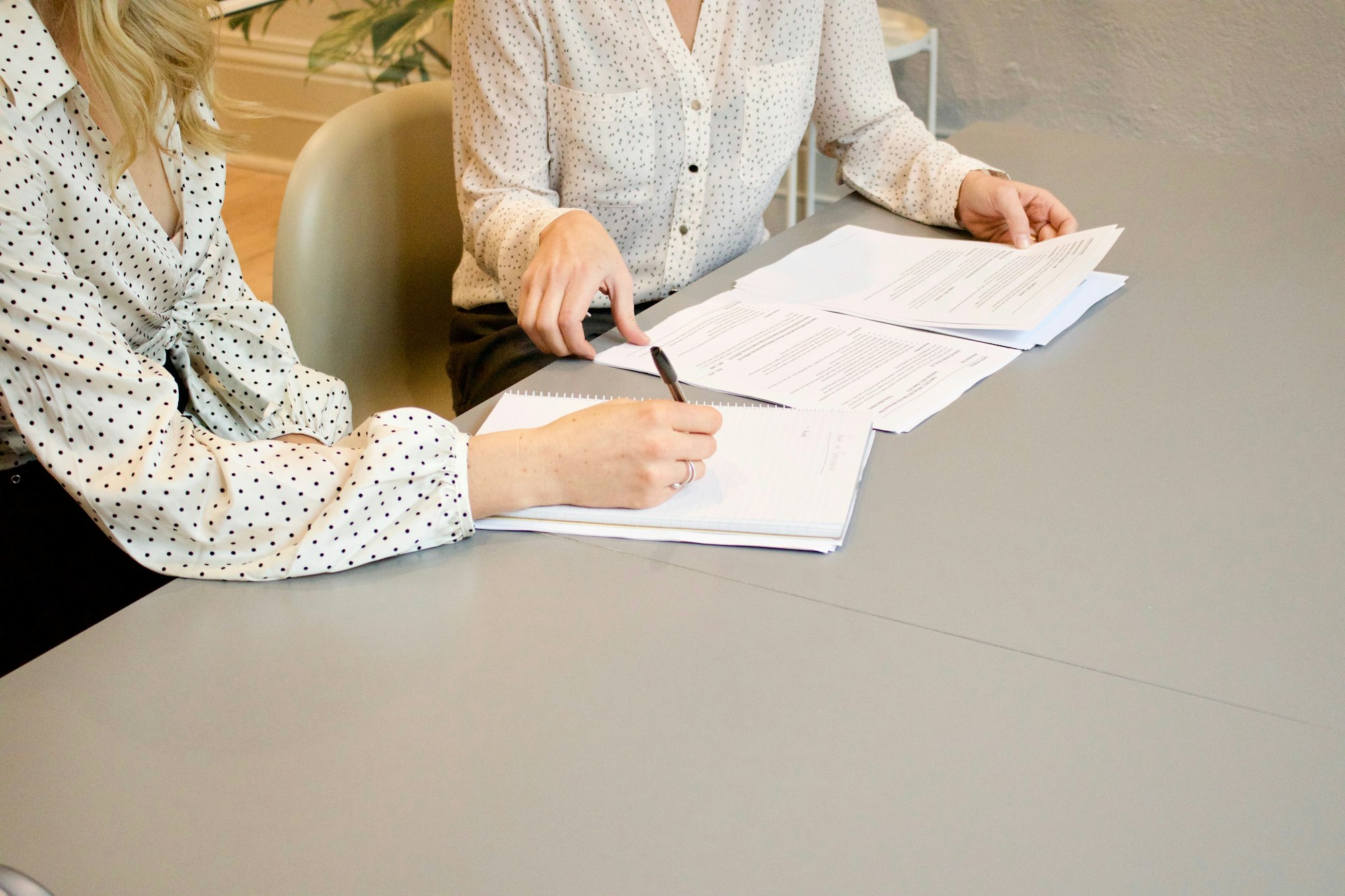 Two people signing paperwork at a table