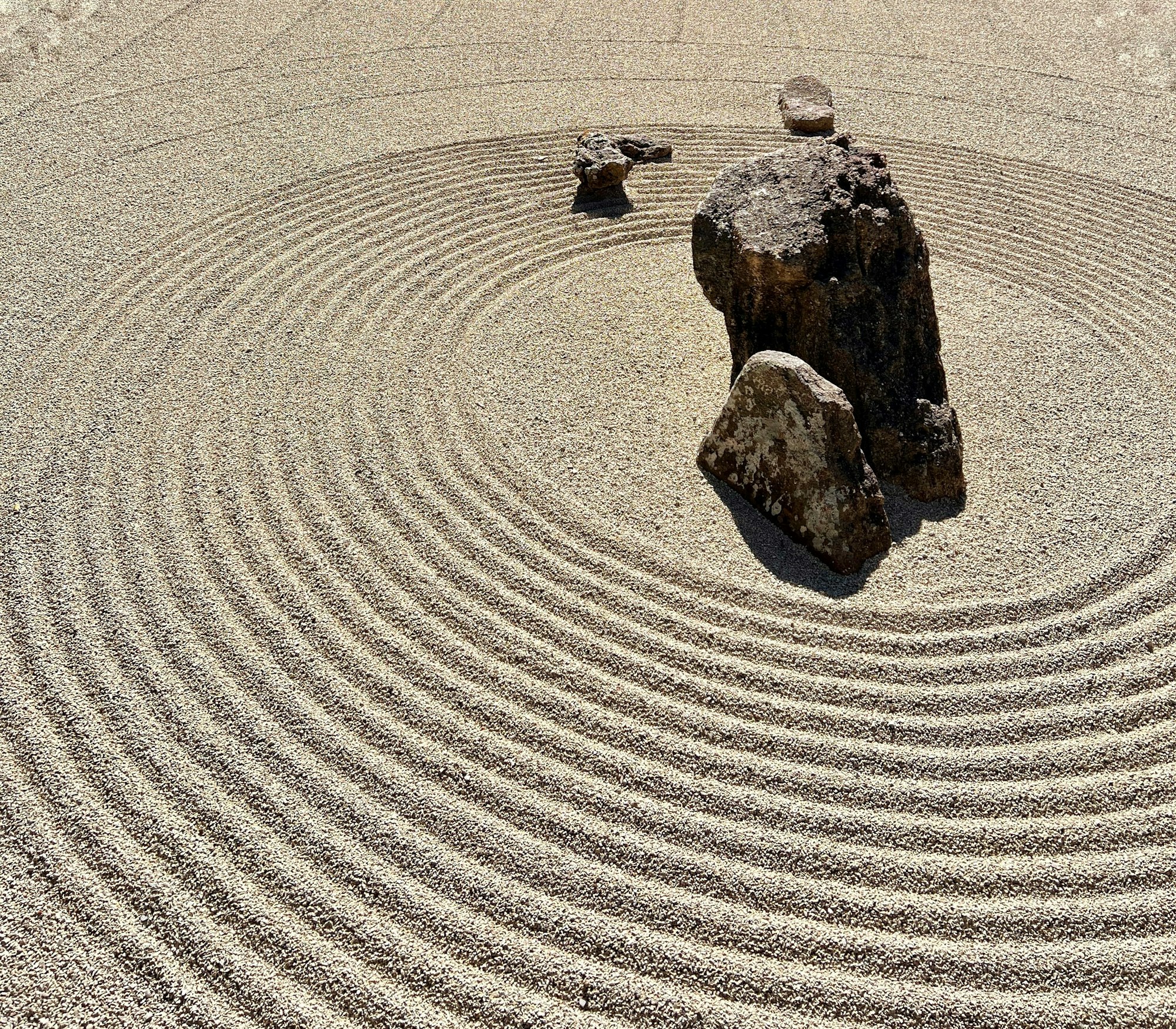 A rock in the center of a raked circular zen garden