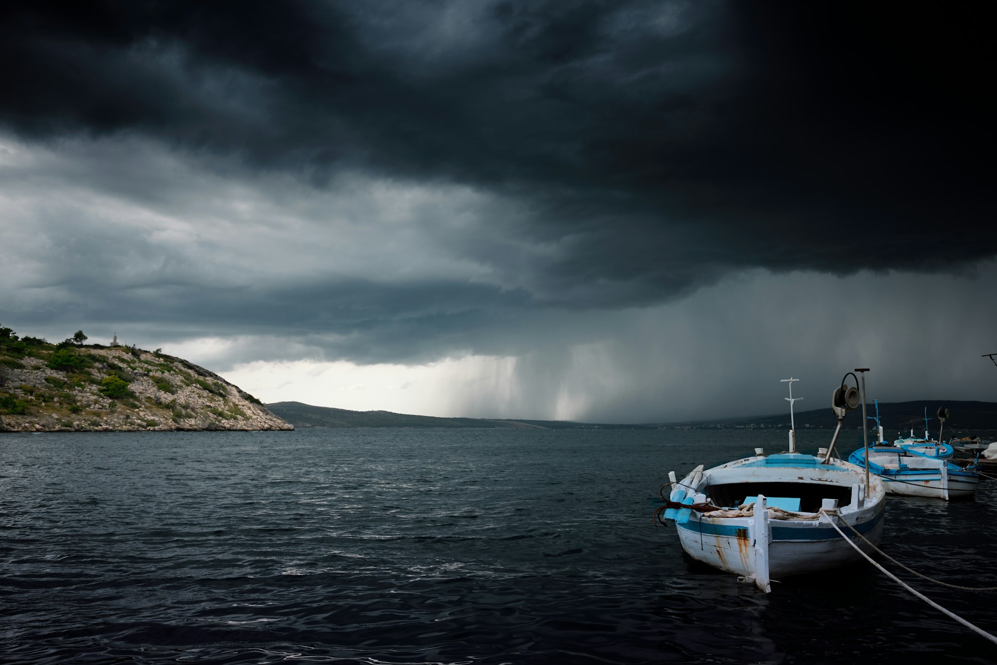 Dark storm clouds over boats at the shore