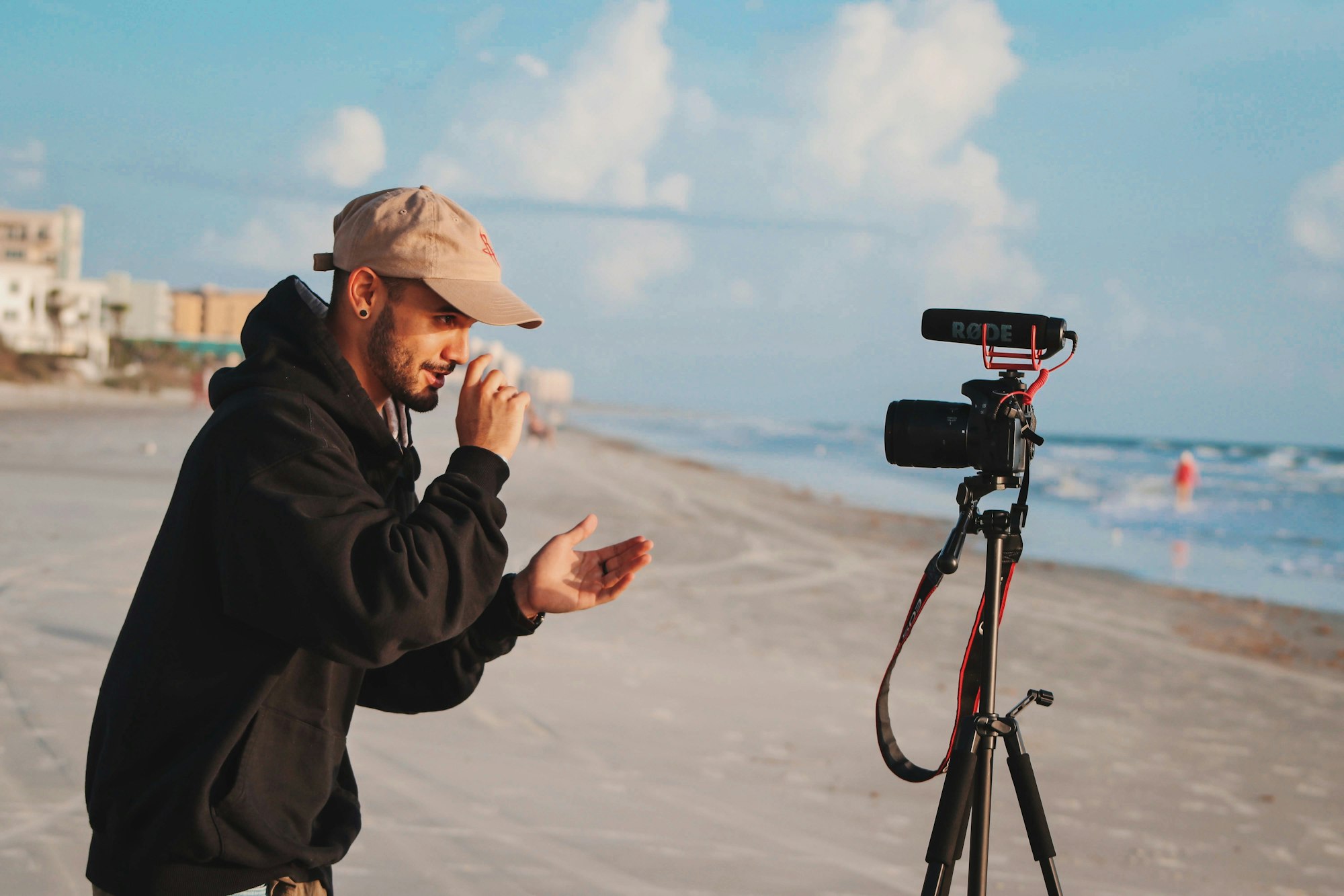 Man in black jacket holding camera during daytime