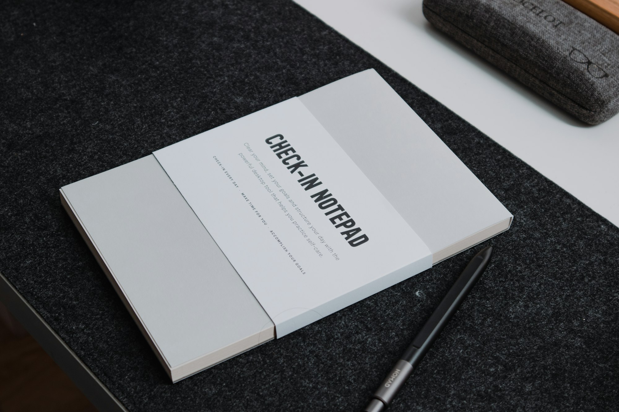 A book sitting on top of a table next to a pen