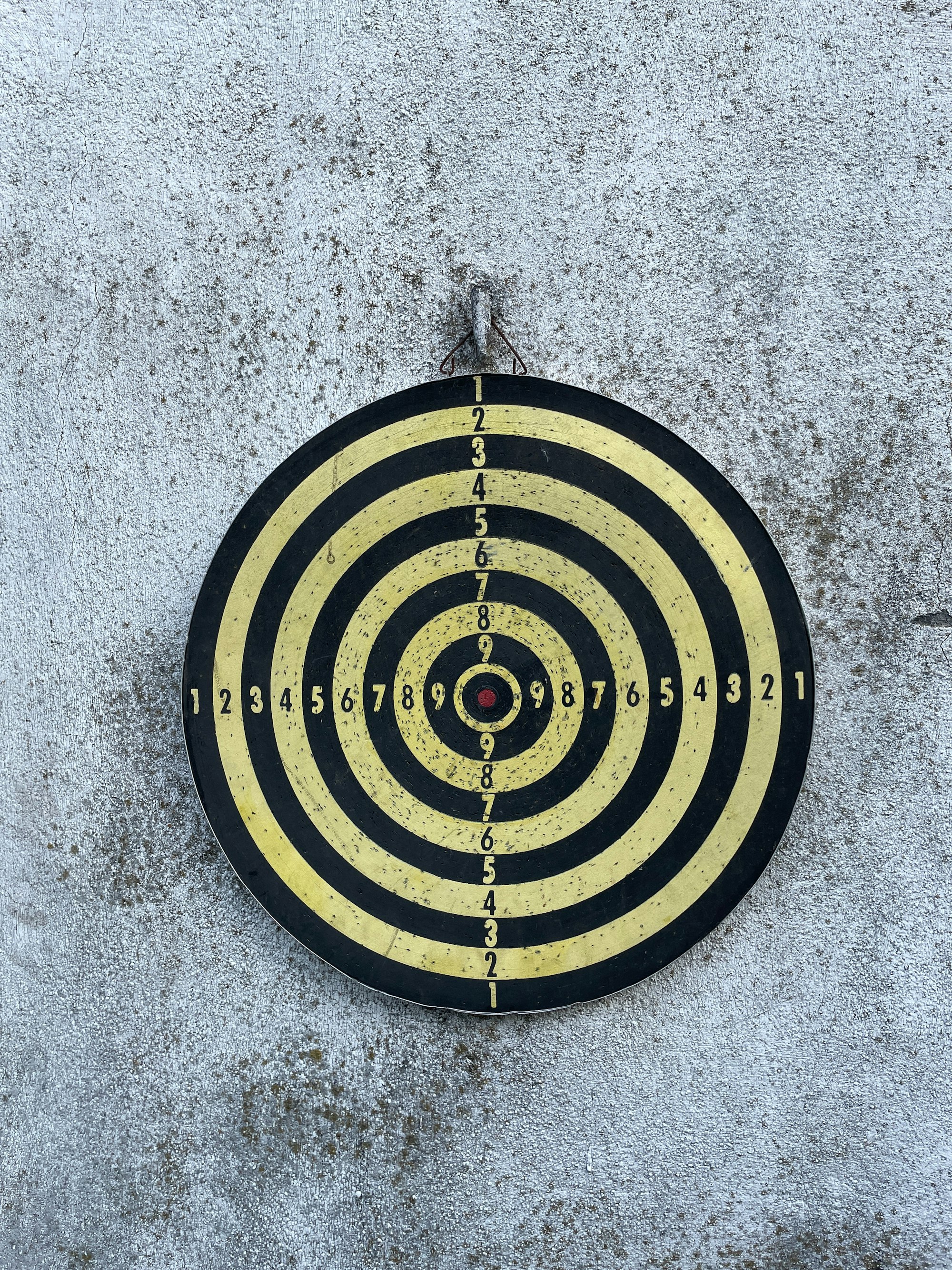 A black and yellow target on a concrete wall