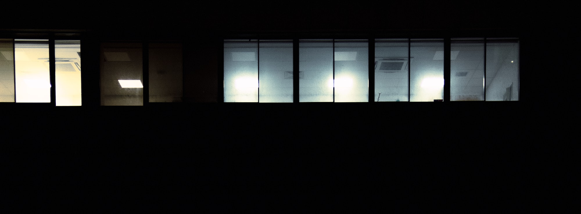 Office windows lit up at night against a dark sky