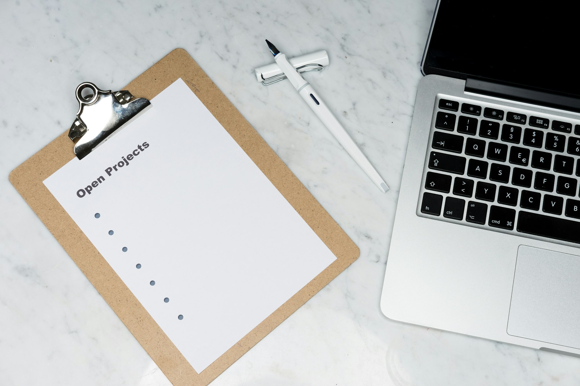 A printed checklist beside a laptop on a desk
