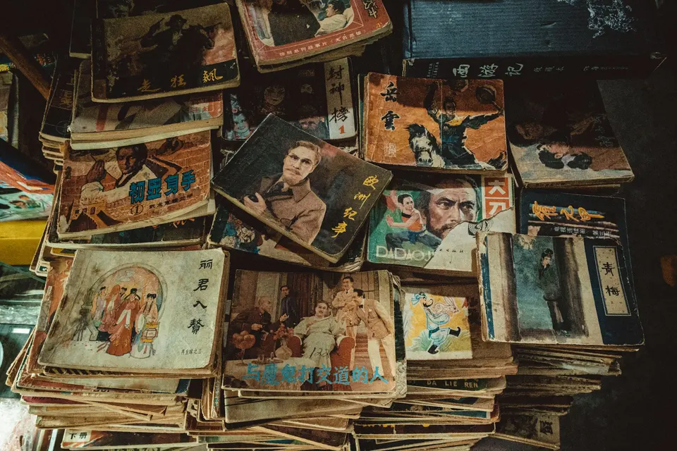 A pile of worn books and magazines with illustrated covers