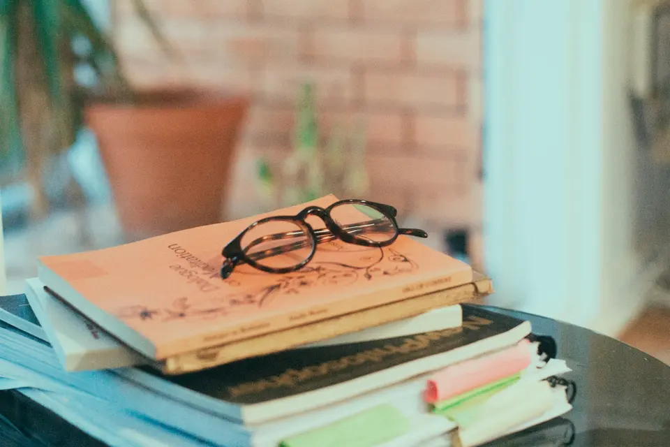 Reading glasses resting on a stack of books