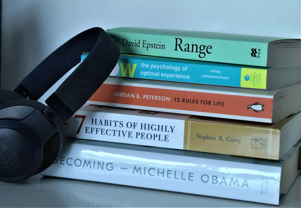 Headphones leaning against a stack of books
