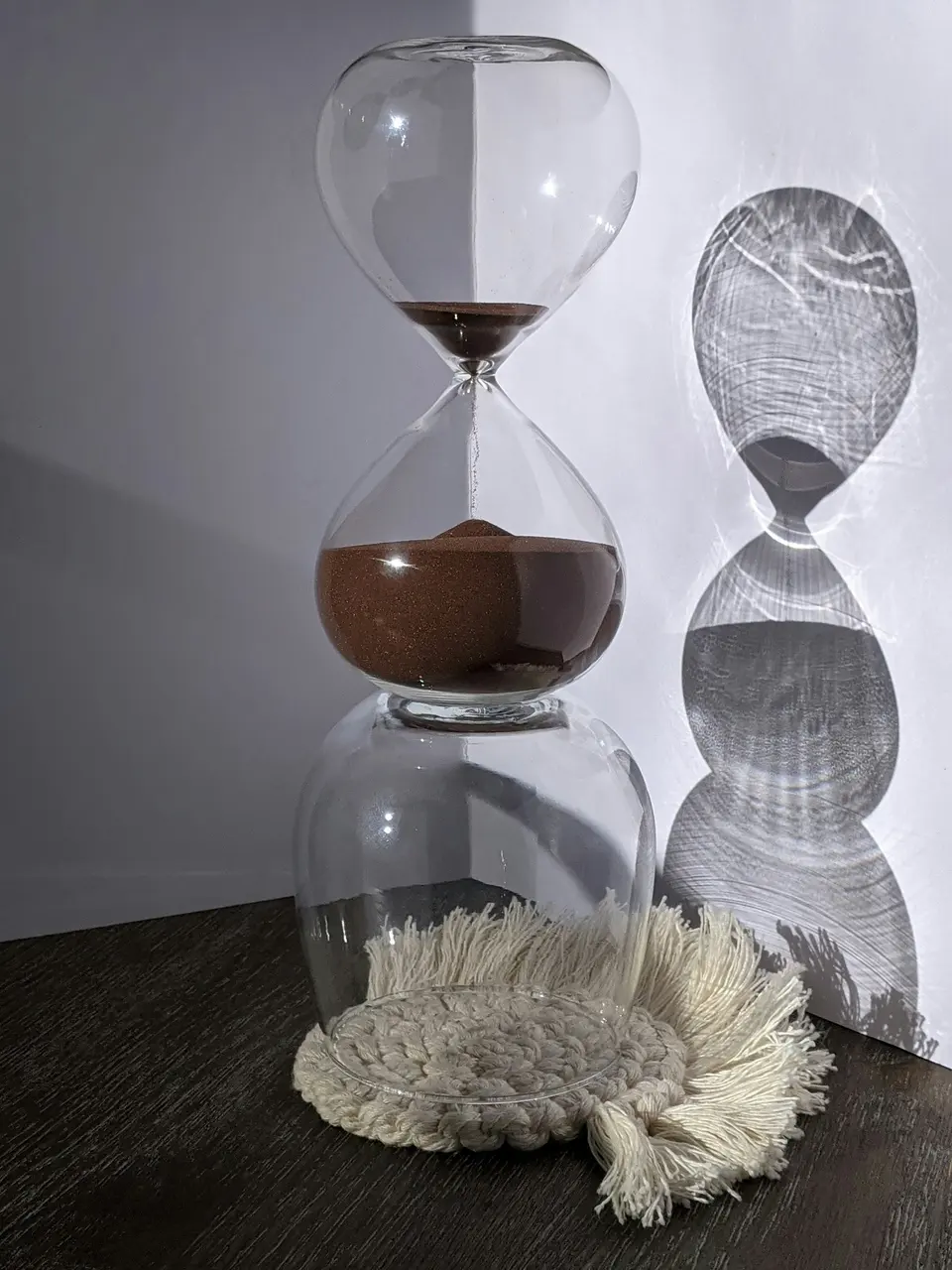 Clear glass hourglass on a black table