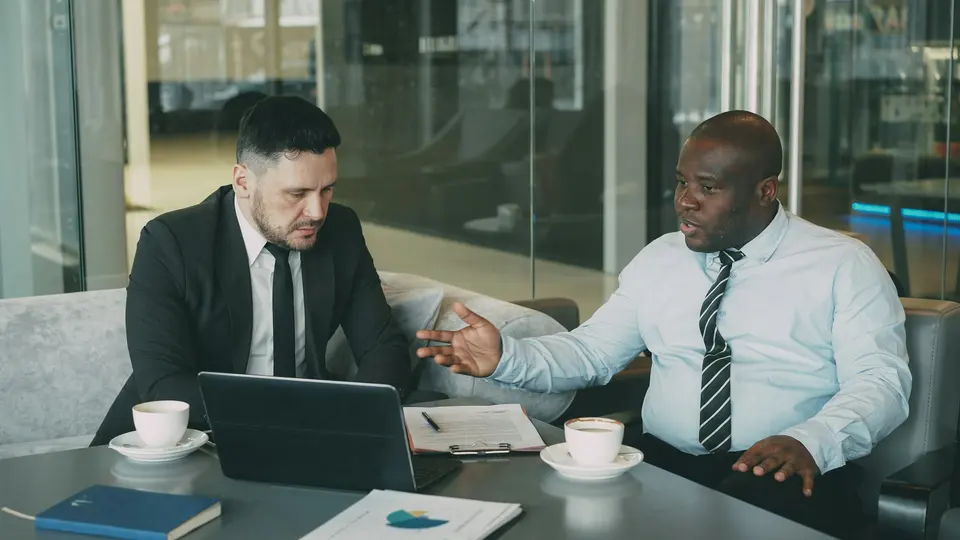 Two businessmen having a serious discussion at a table