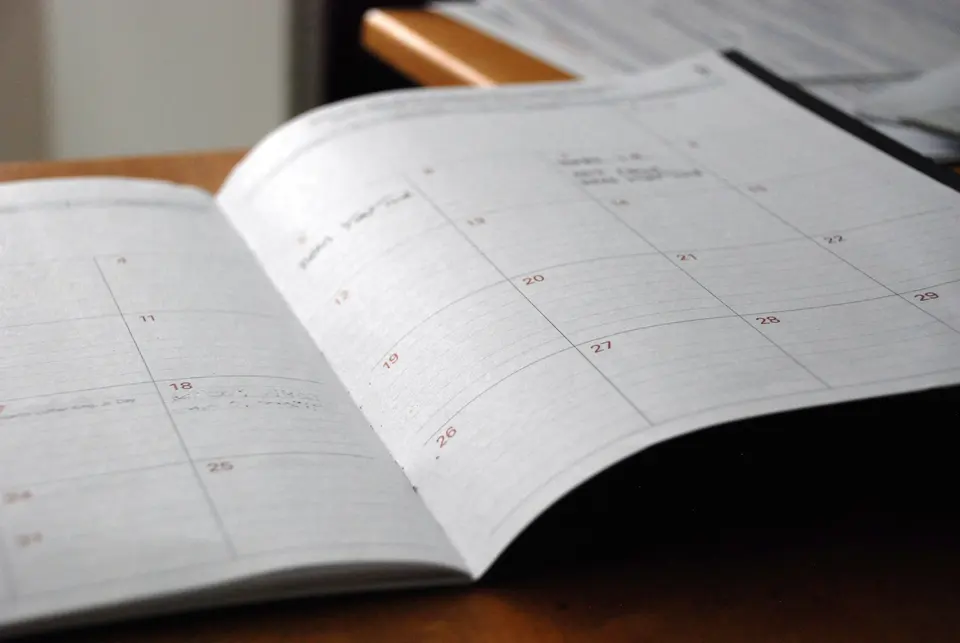 An open monthly planner on a wooden desk