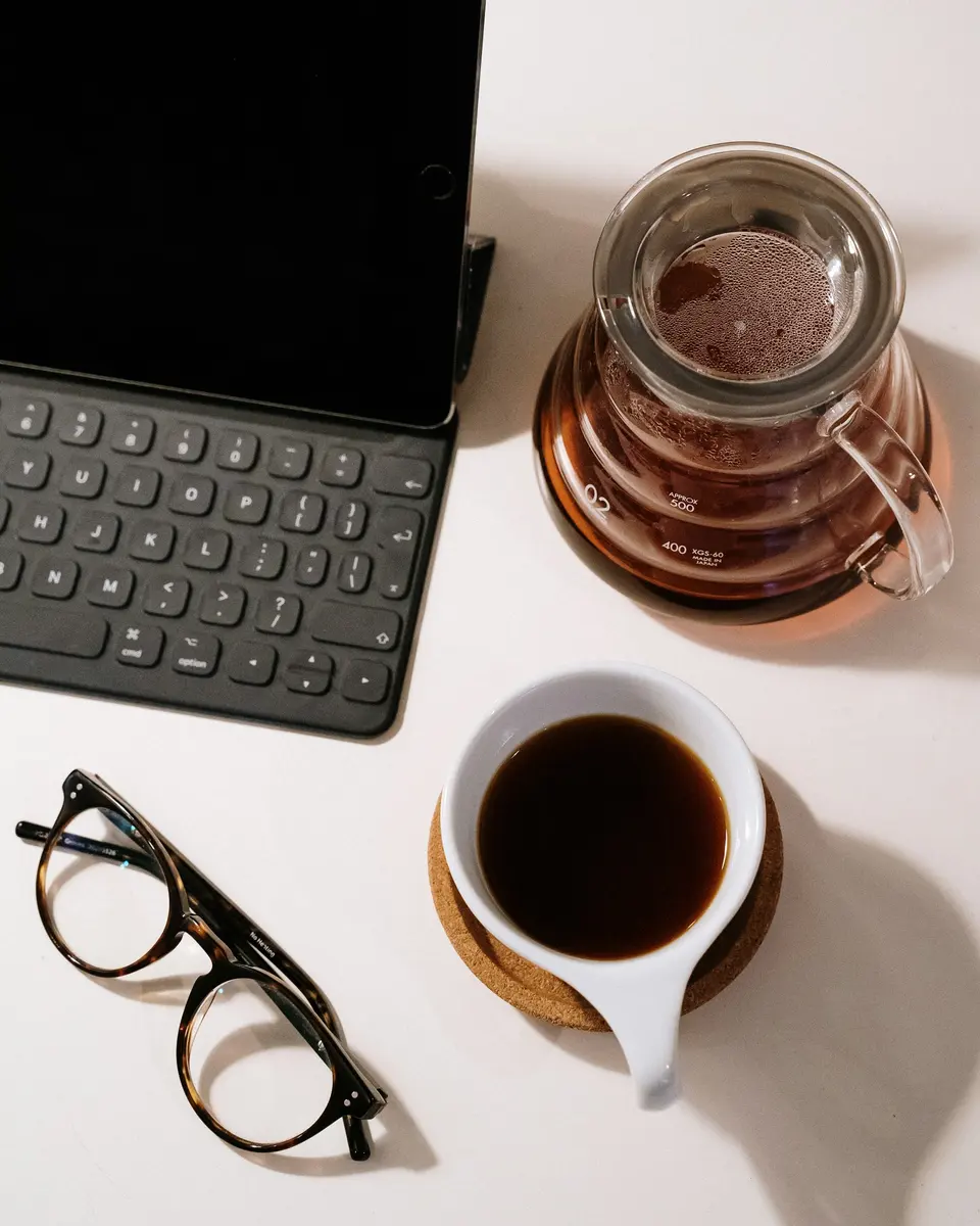 Black framed eyeglasses beside black laptop computer