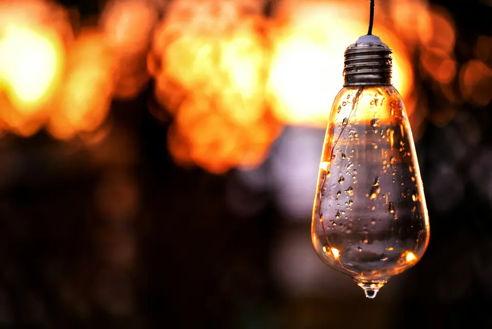 Clear glass pendant lamp turned on with bokeh background