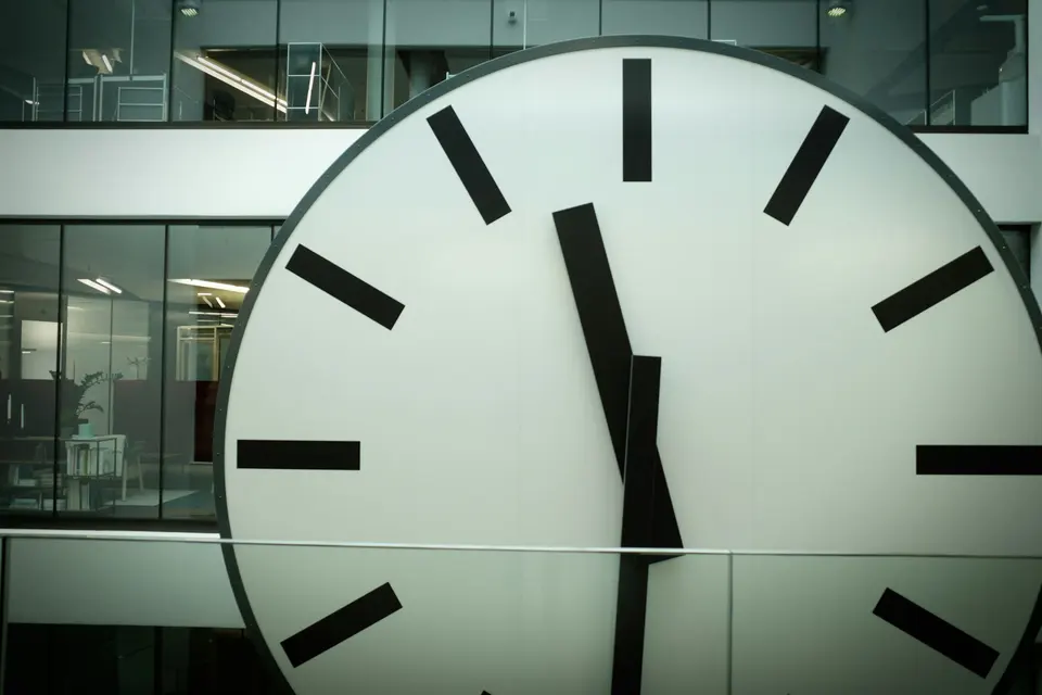 Large round clock in front of glass windows