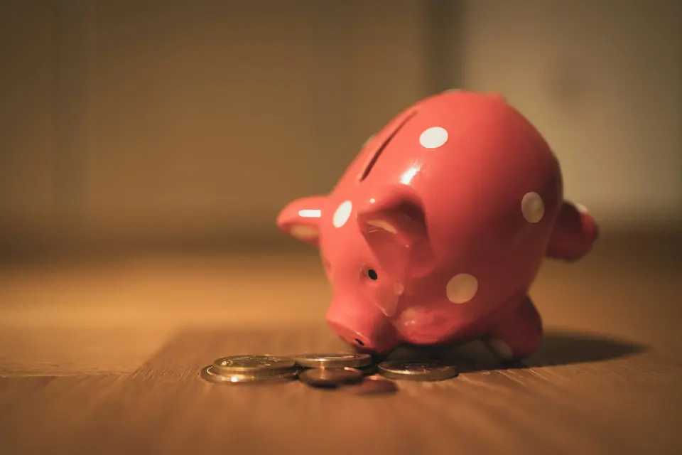 A pink piggy bank on a wooden table