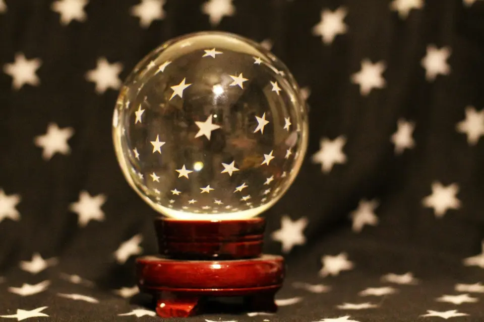A glass sphere on a wooden base surrounded by star patterns