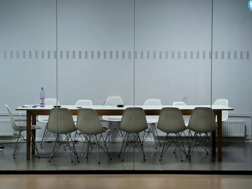 An empty meeting room with a long table and chairs