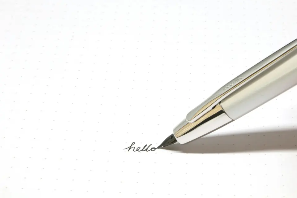 Silver click pen on white paper
