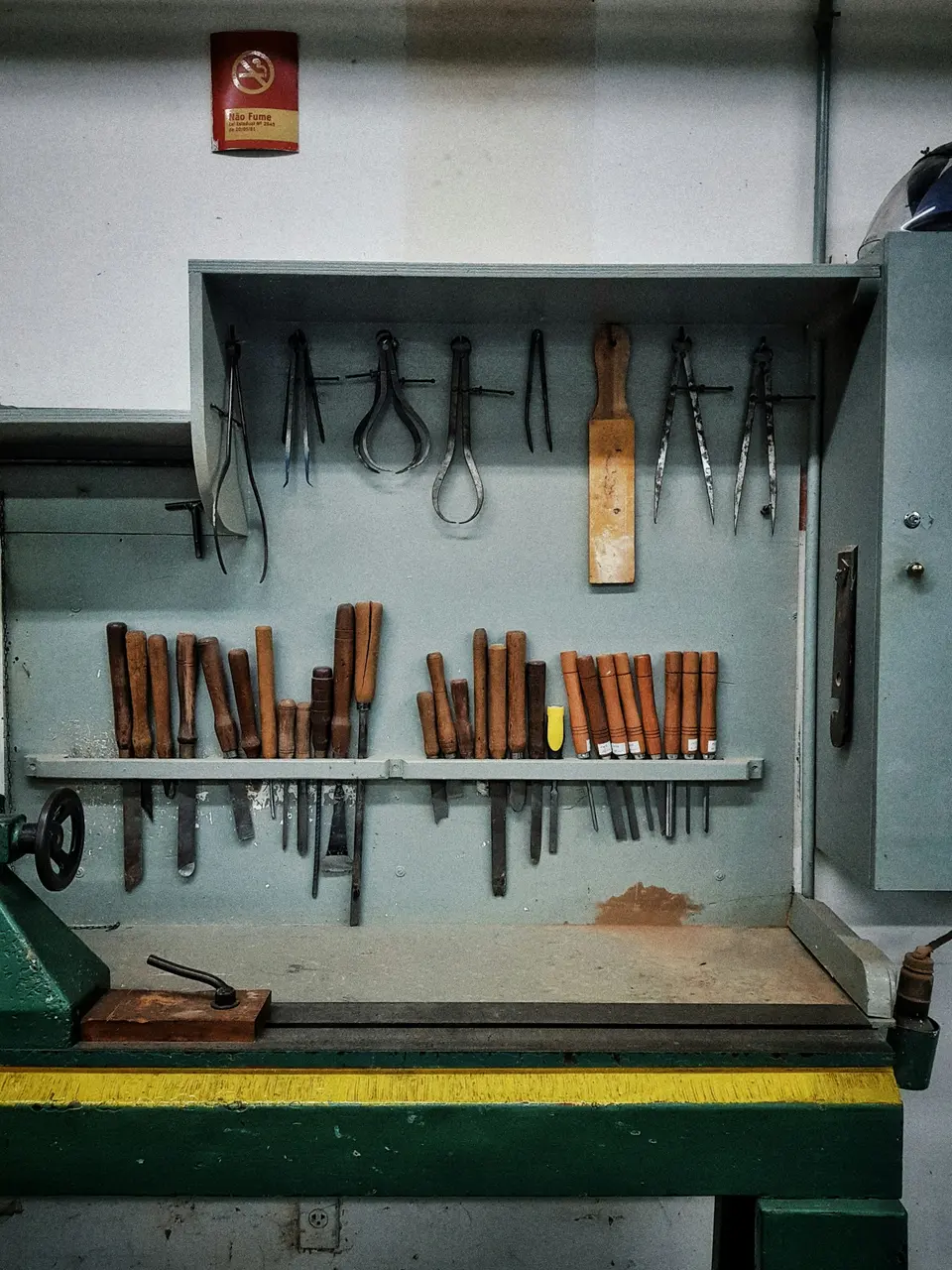 Hand tools arranged on a metal rack above a workbench