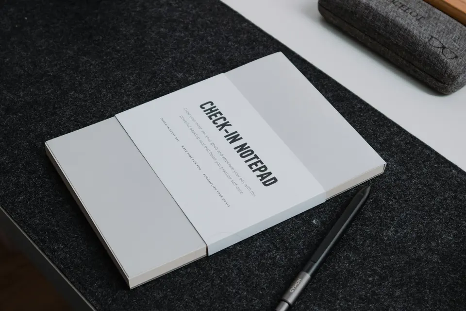 A book sitting on top of a table next to a pen